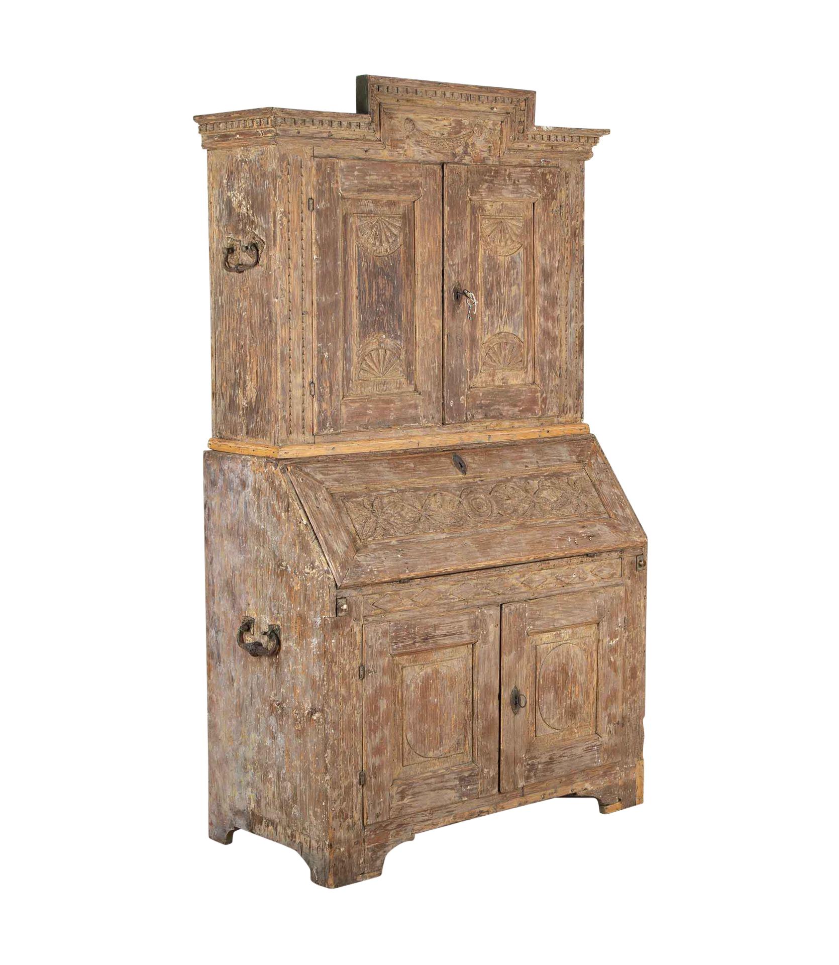 An early 19th Century Gustavian secretary from Skåne, Sweden.
With decorative carved pediment and decorated doors opening to storage. Below, a fall front desk opening to workspace and drawers and further below, two doors with further