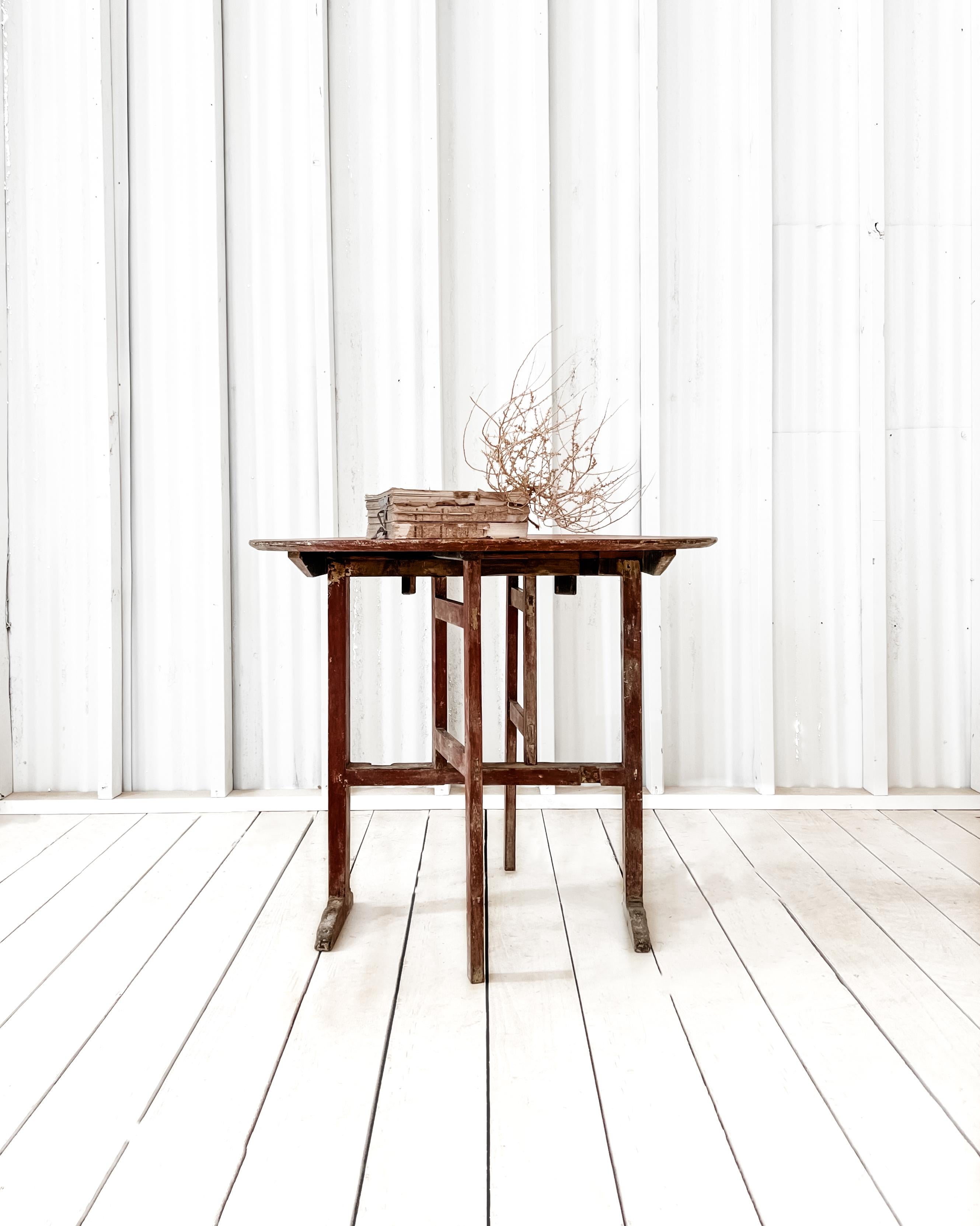 Once used for serving tea, drinks, or desserts during dinner parties and gatherings in the past, this table’s unique design allows it to be neatly tucked away when not in use. Featuring a beautiful shade of “Swedish pink” paint, with a dry-scraped