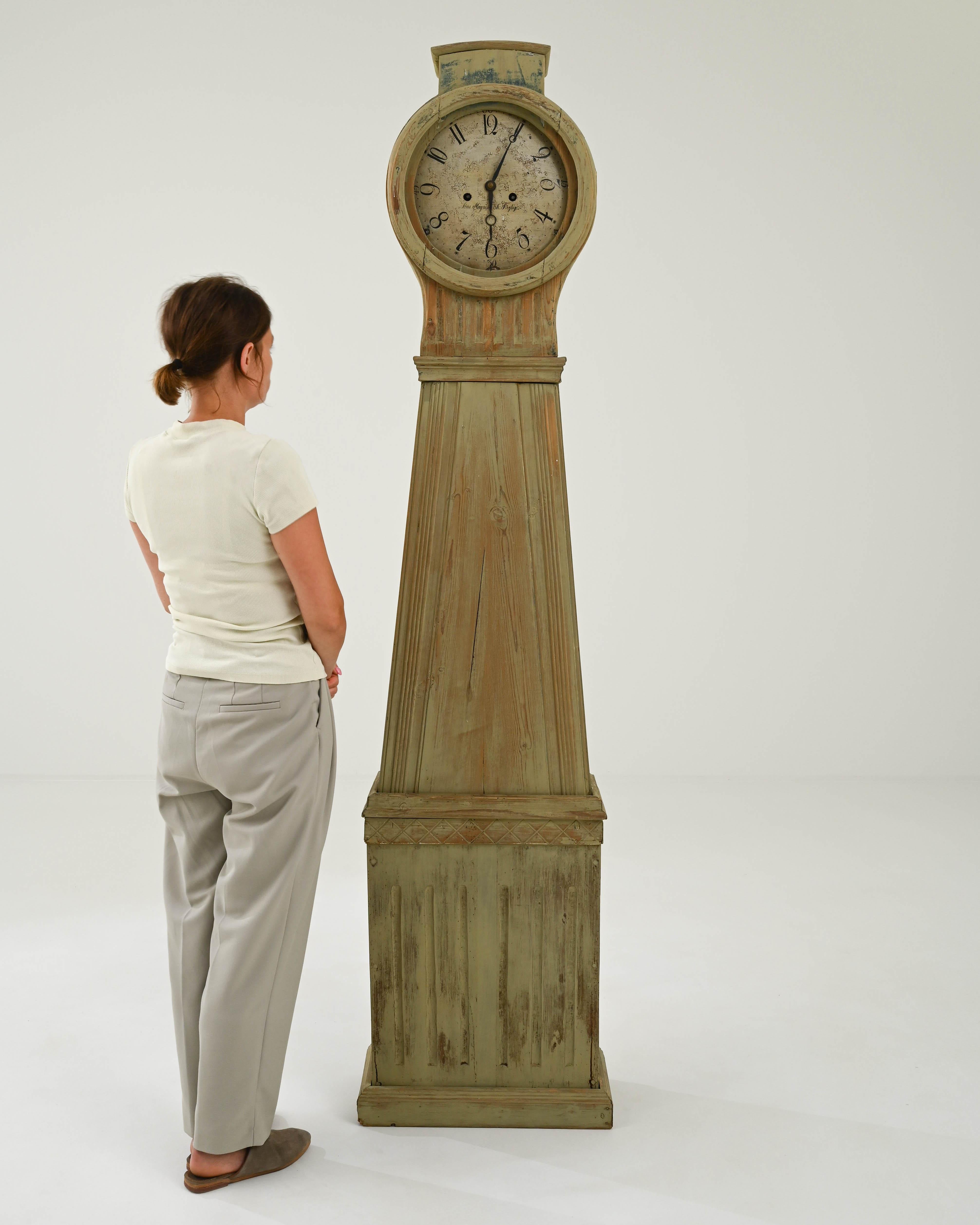 This antique wooden clock combines a striking silhouette with a muted patina. Built in Sweden in the early 1800s, the elegant simplicity of the design reflects the Gustavian style in vogue at the time. Clean lines and the pyramidal shape of the