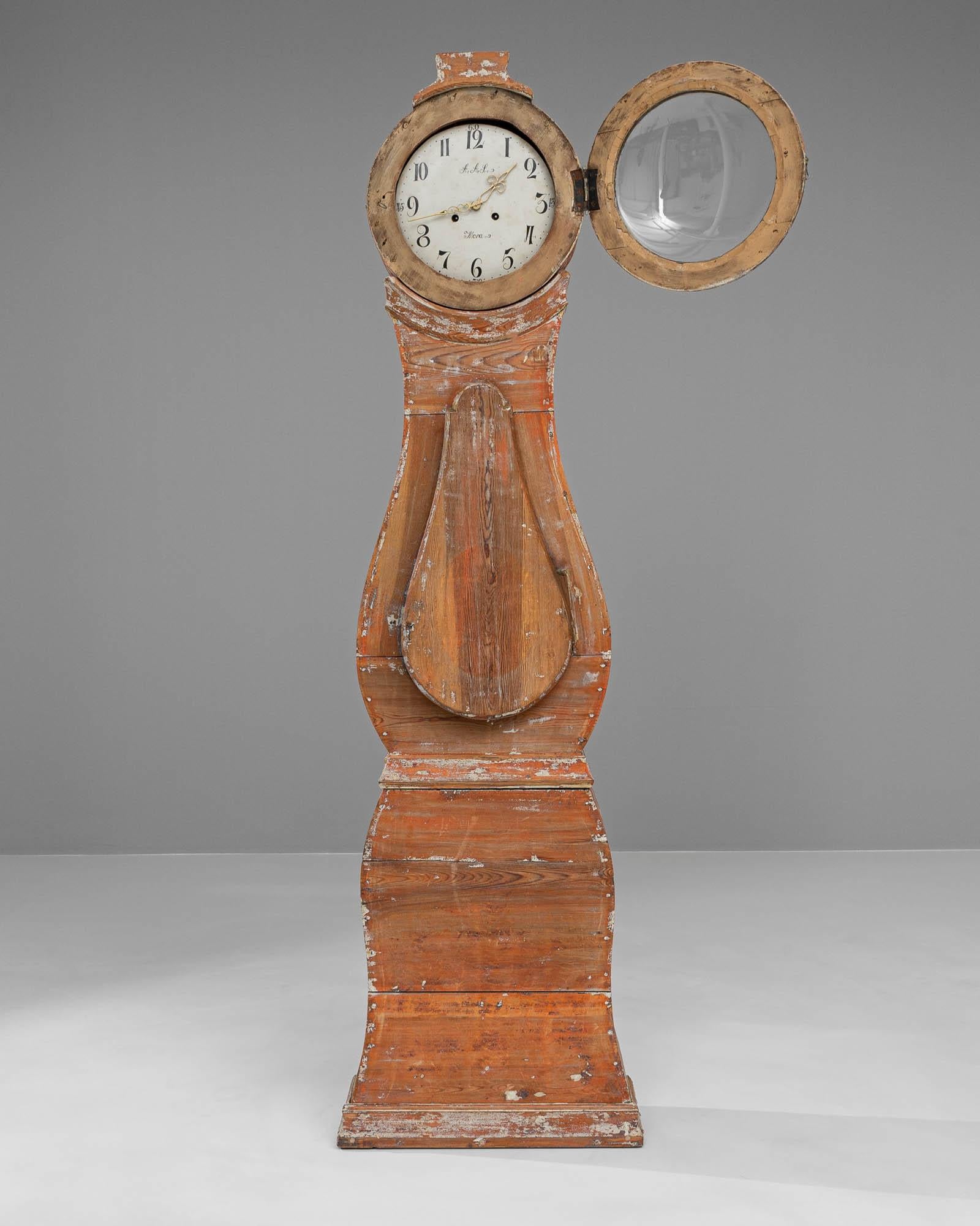 Cette horloge de sol suédoise en bois du début du XIXe siècle est un trésor rustique, qui fait écho à la simplicité et à la durabilité du design scandinave. Sa surface en bois vieilli, qui arbore la teinte chaude et rougeâtre du chêne usé par le