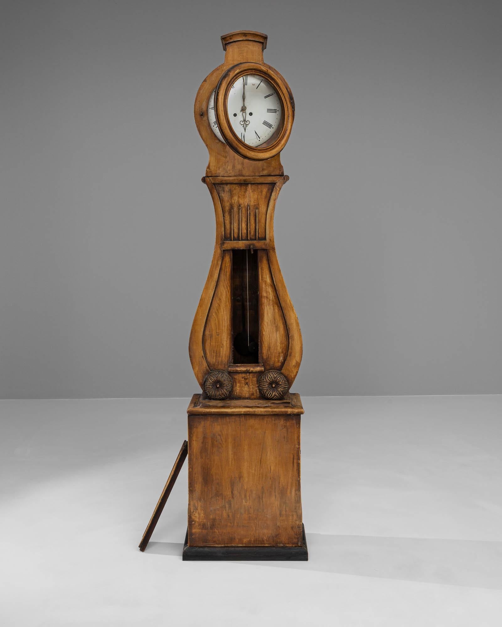 Admirez le charme de cette horloge en bois suédoise du début du XIXe siècle, un chef-d'œuvre de l'antiquité qui capture l'essence de son époque. Sa construction en chêne robuste se tient debout, avec une patine naturelle riche qui raconte l'histoire