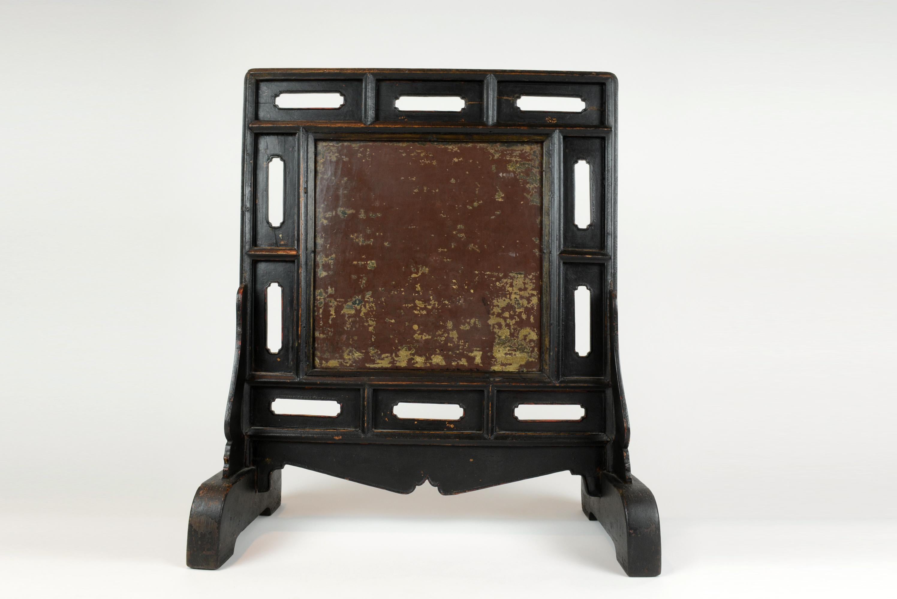 This black lacquer table screen has a multi –panel frame. Each section surrounding the stone has an elongated open begonia. The apron is cusped. The base is attached to the screen in mortise and tenon joints.
The base of this screen is 11.5 inches