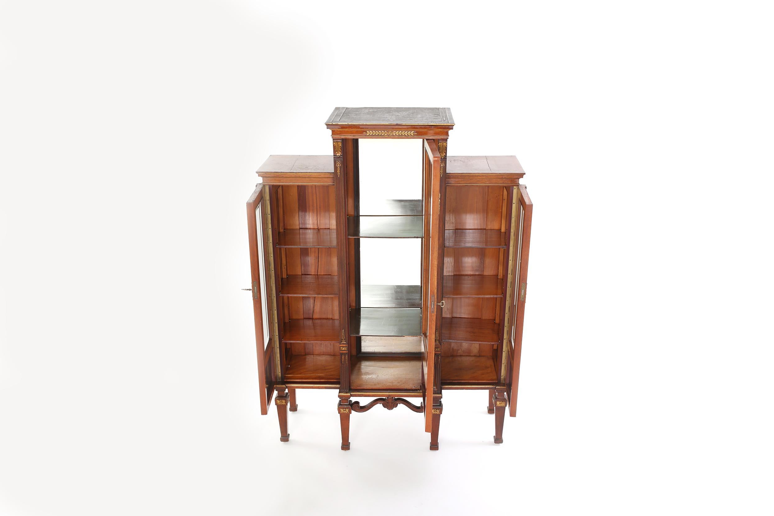 Early 19th century mahogany wood three part French display china cabinet with interior mirrored details. The display cabinet is in good antique condition with age / use appropriate wear. The piece stand about 63 inches high x 43.5 inches wide x 17