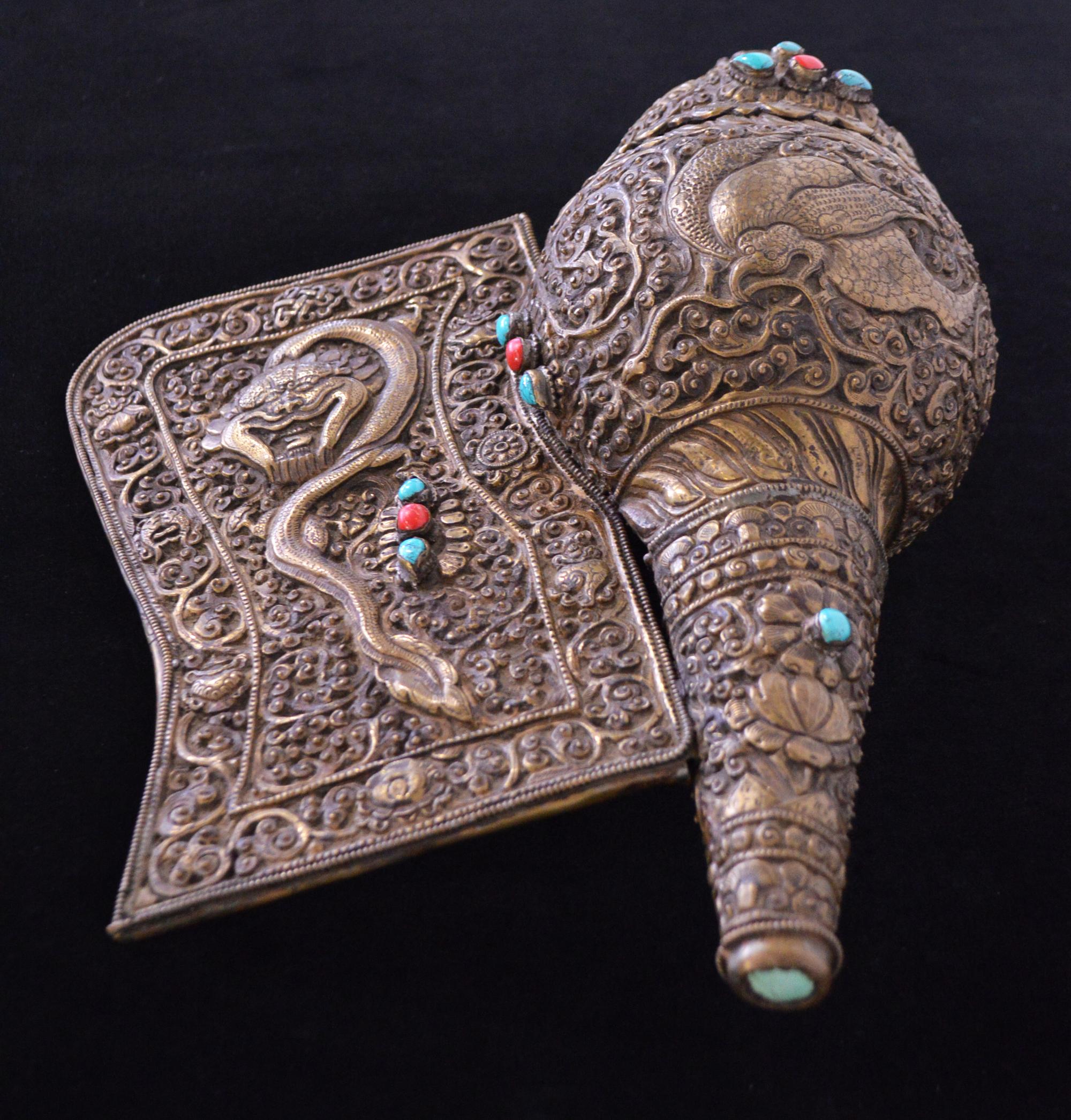 Beautiful early 19th century Tibetan cerimonial trumpet formed by a natural seashell covered in hammered bronze with visible coral and turquoise details. The seashell was used since ancient time as a ritual tool and represents the abandonment of