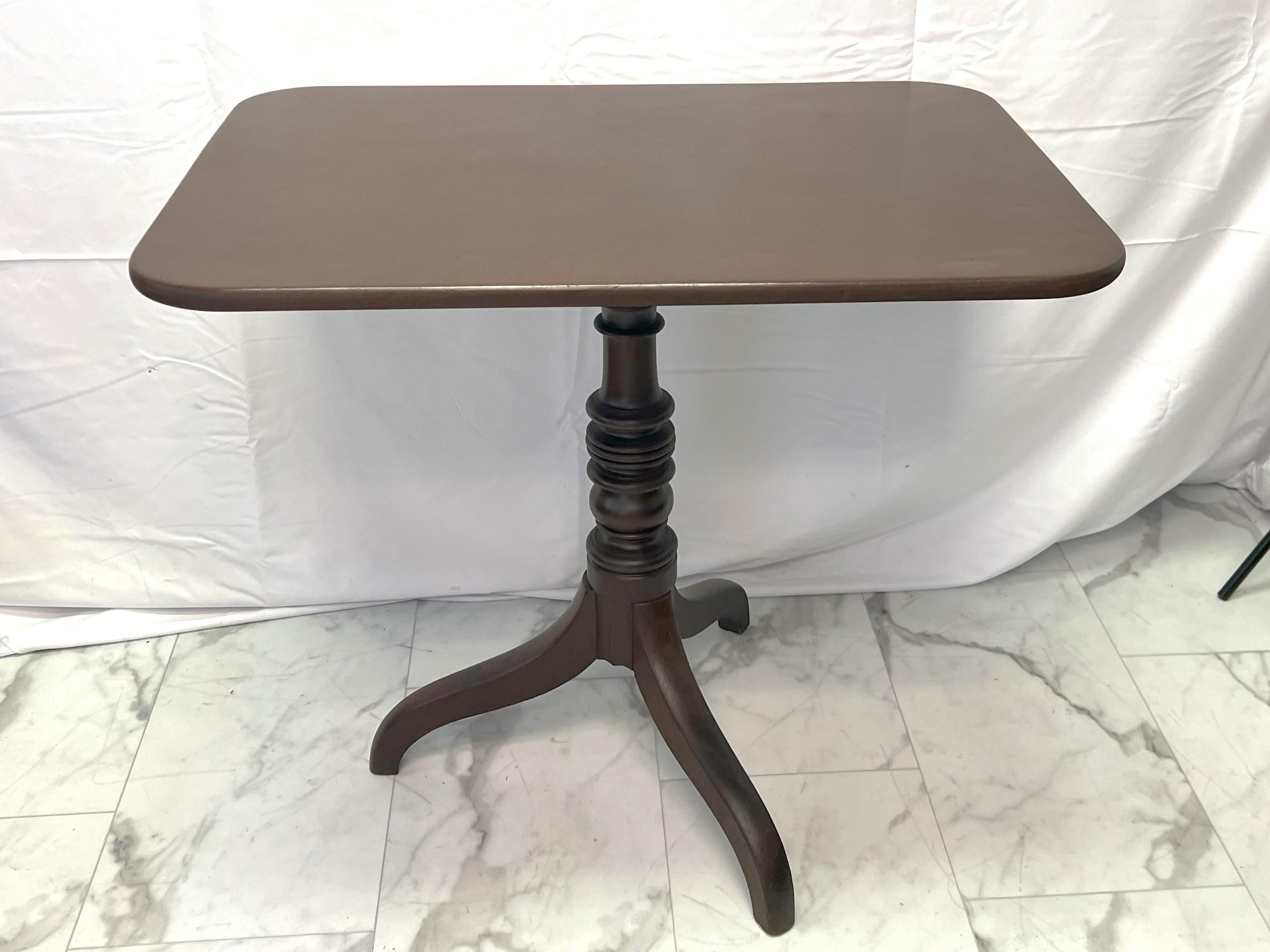 Early 19th-century tilt-top occasional table circa 1810. The rectangular top with rounded corners. Standing on a turned stem and supported by 3 scrolling legs. The tilting mechanism allows easier storage. Ideal for use as a lamp or side table. Minor