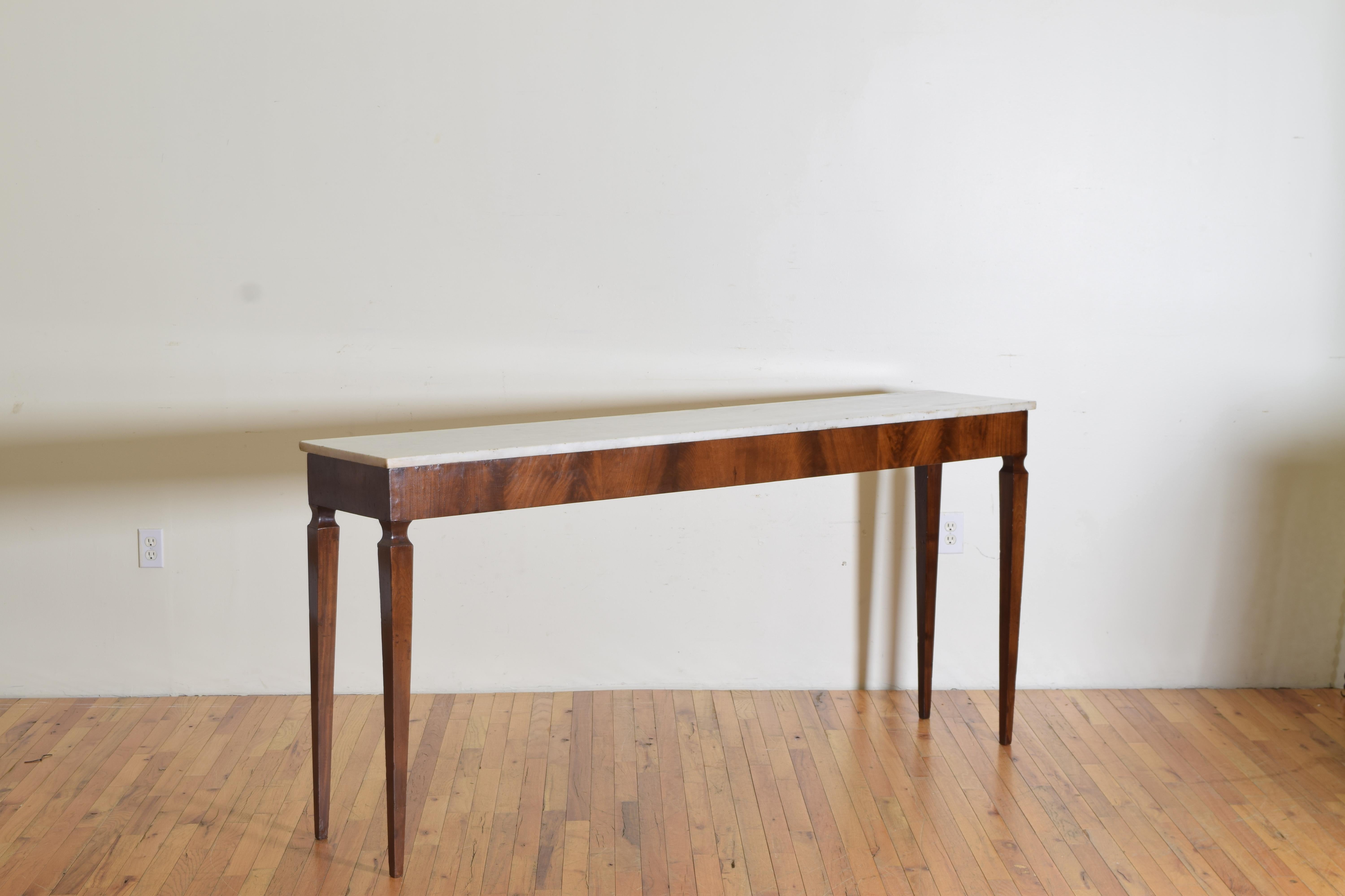Highly functional for serving as this piece is tall in height and lean in depth with an easily maintainable marble top. Elegant in style this piece is from the early 19th century.