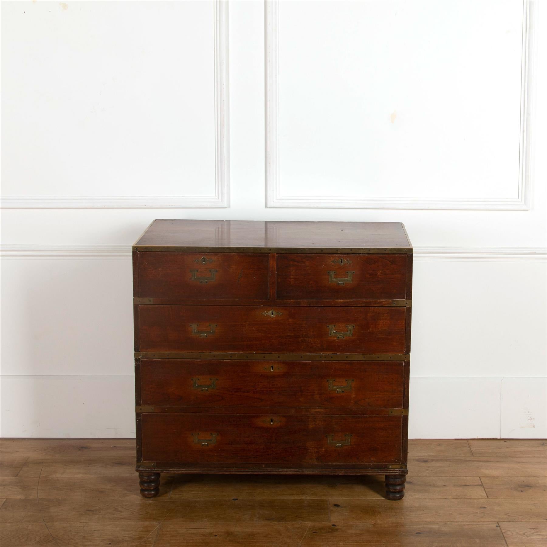 An early 19th century teak, brass bound two part military chest of drawers.