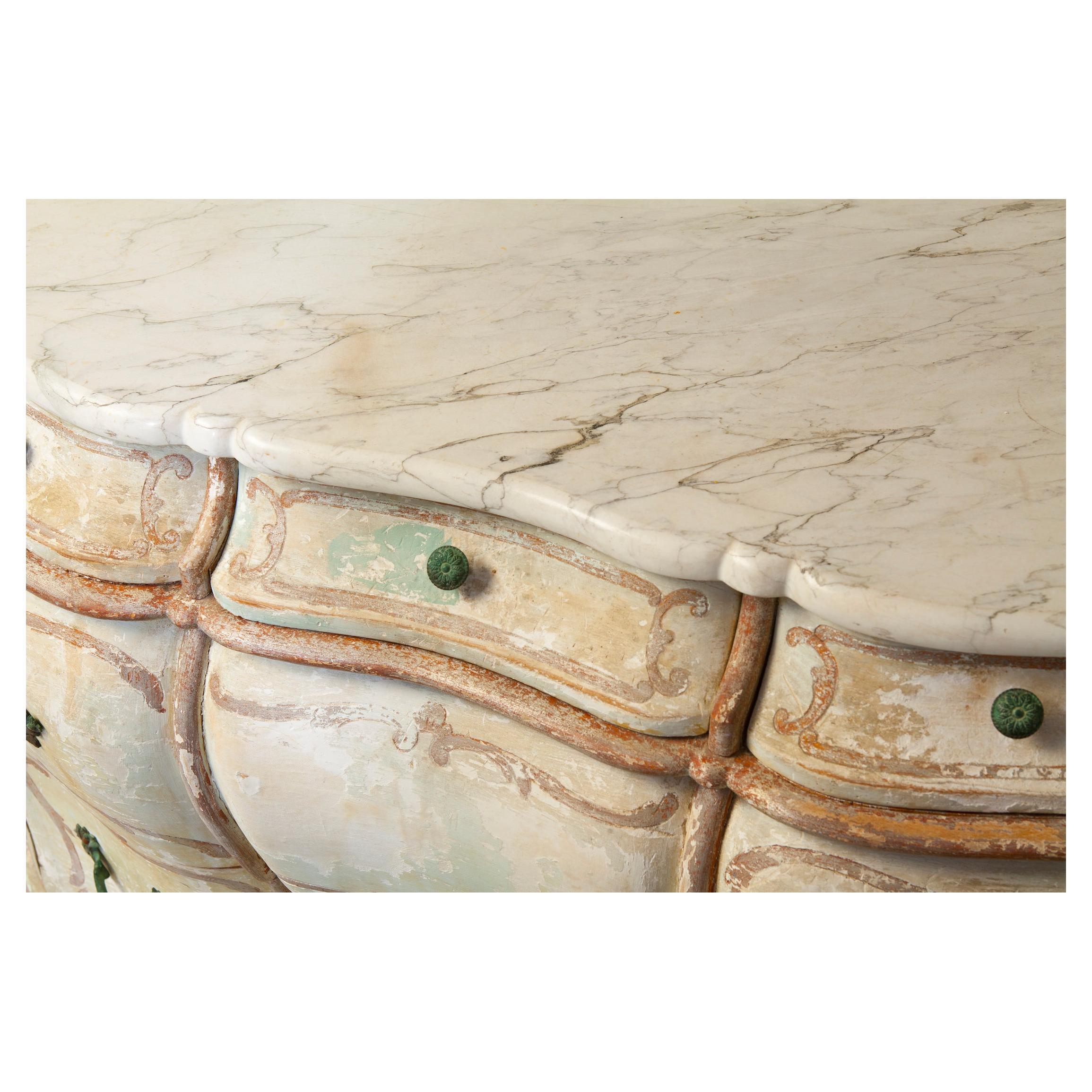 Hand painted Venetian Bombe chest with an aged patina of blues, greens and golds. Sculpted drawer facades. Whimsical hand painted finish over gauzy gesso, which peeks through the finish. Three small draws on top and two roomy drawers below. Marble