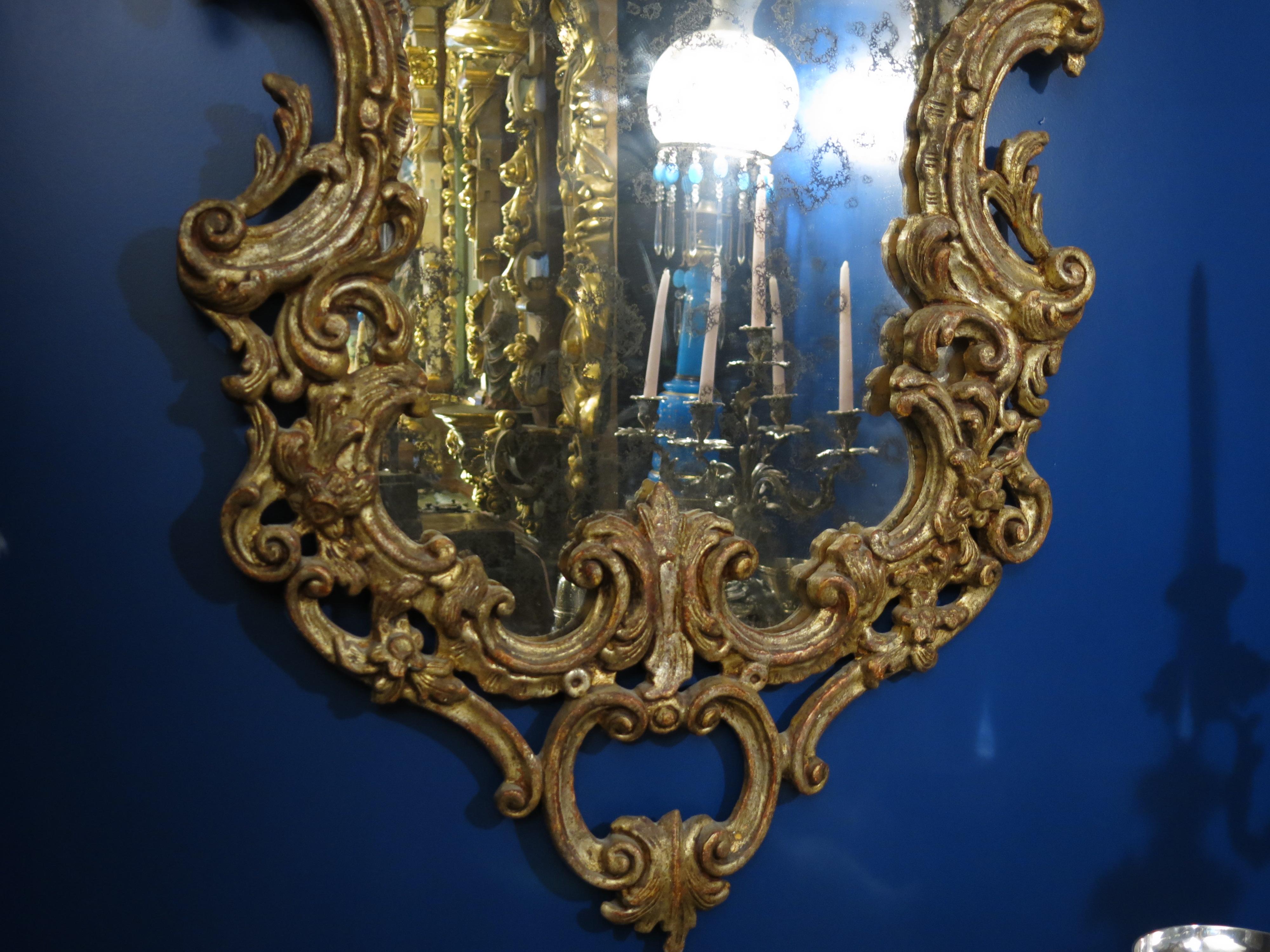 Indulge in the timeless allure of Venetian craftsmanship with this magnificent antique Venetian mirror. Crafted from gilt wood with a striking baroque influence, it exudes opulence and grandeur, capturing the essence of Venetian elegance. In
