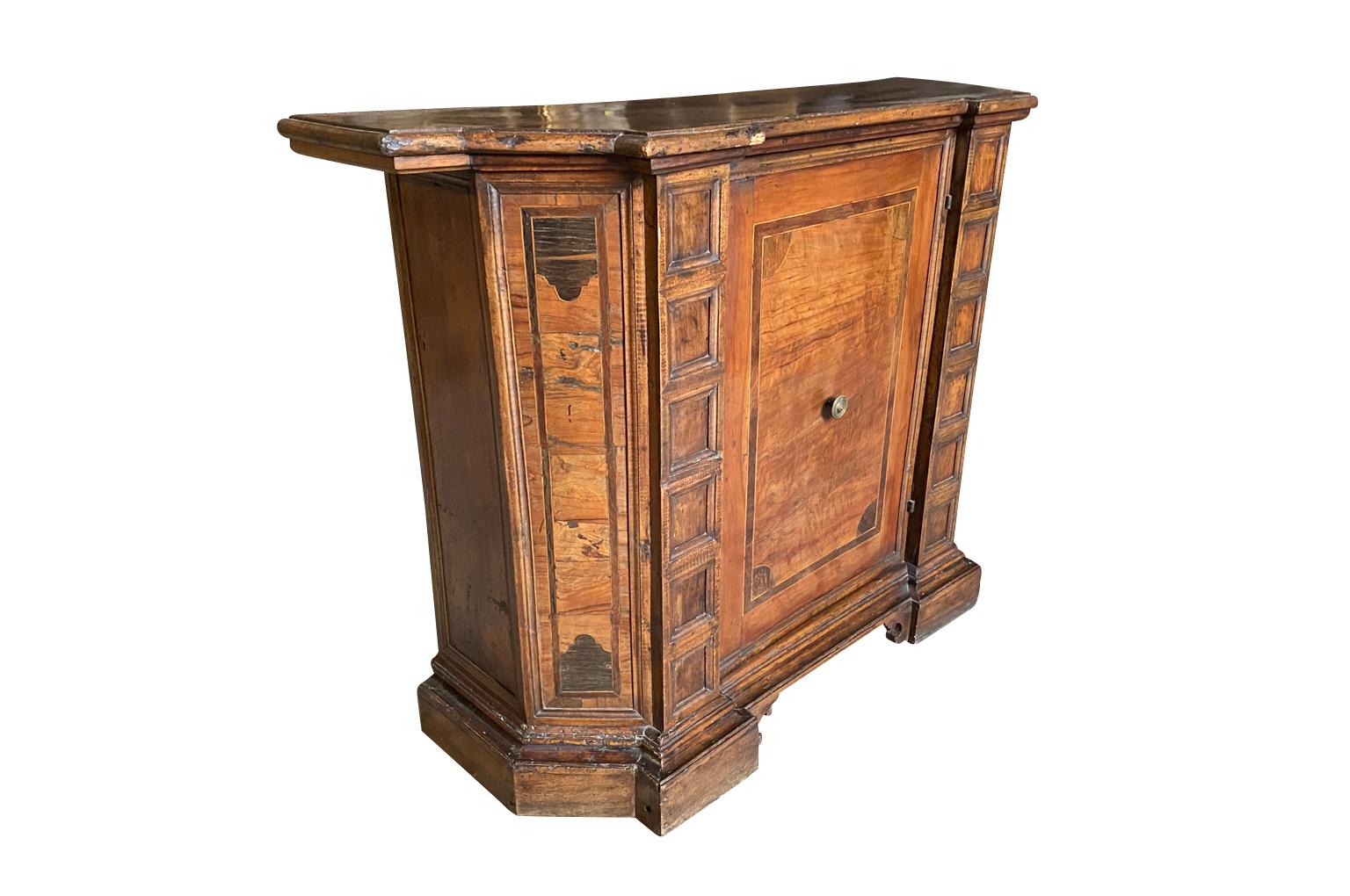 A very striking early 19th century narrow credenza from the Veneto region of Italy. Beautifully constructed from very handsome walnut with canted sides - scantonata - with a single door raised on bracket feet.
