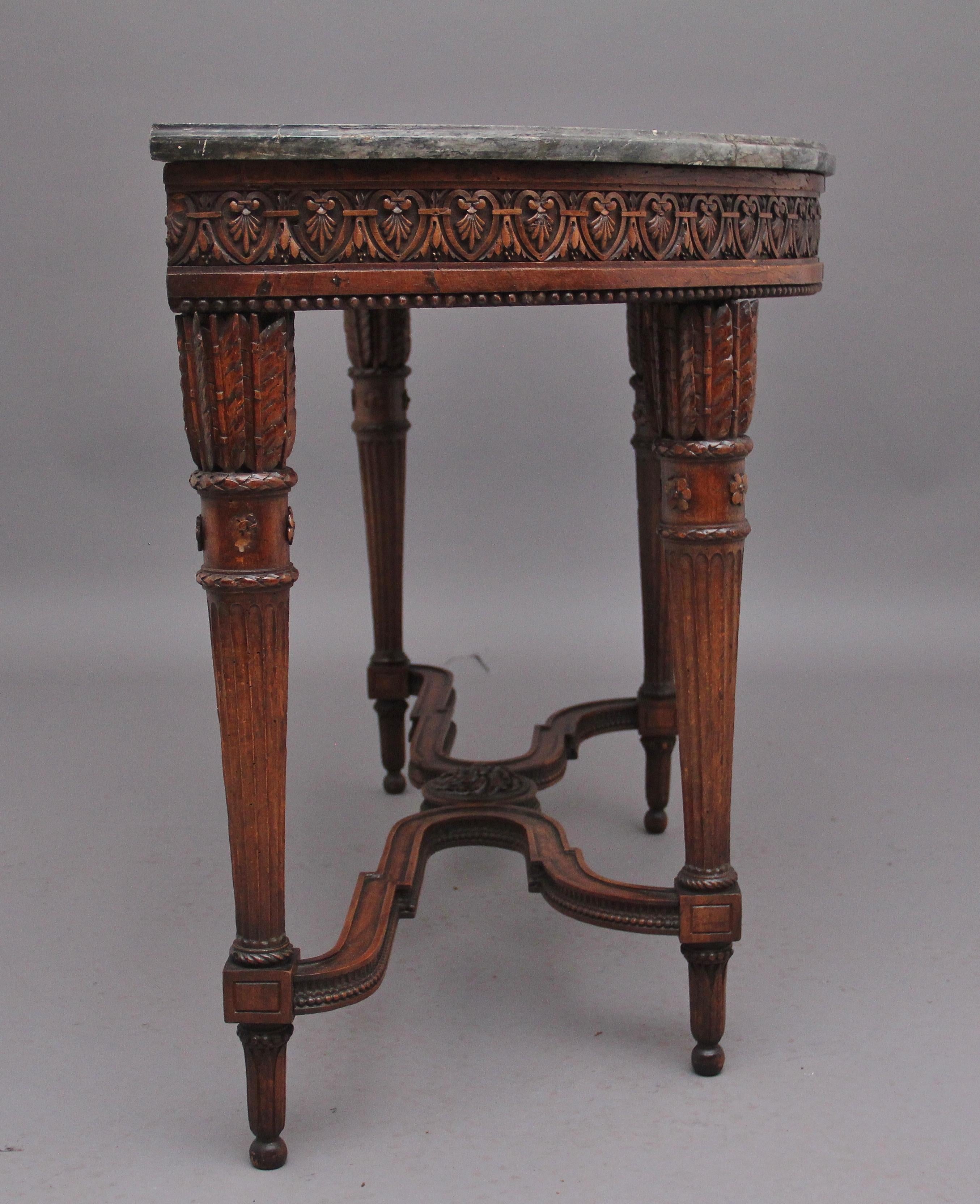 A superb quality early 19th Century French walnut and marble top console table, having the original and repaired shaped and moulded edge grey veined marble top above a profusely carved and highly decorative frieze incorporating intricate carved