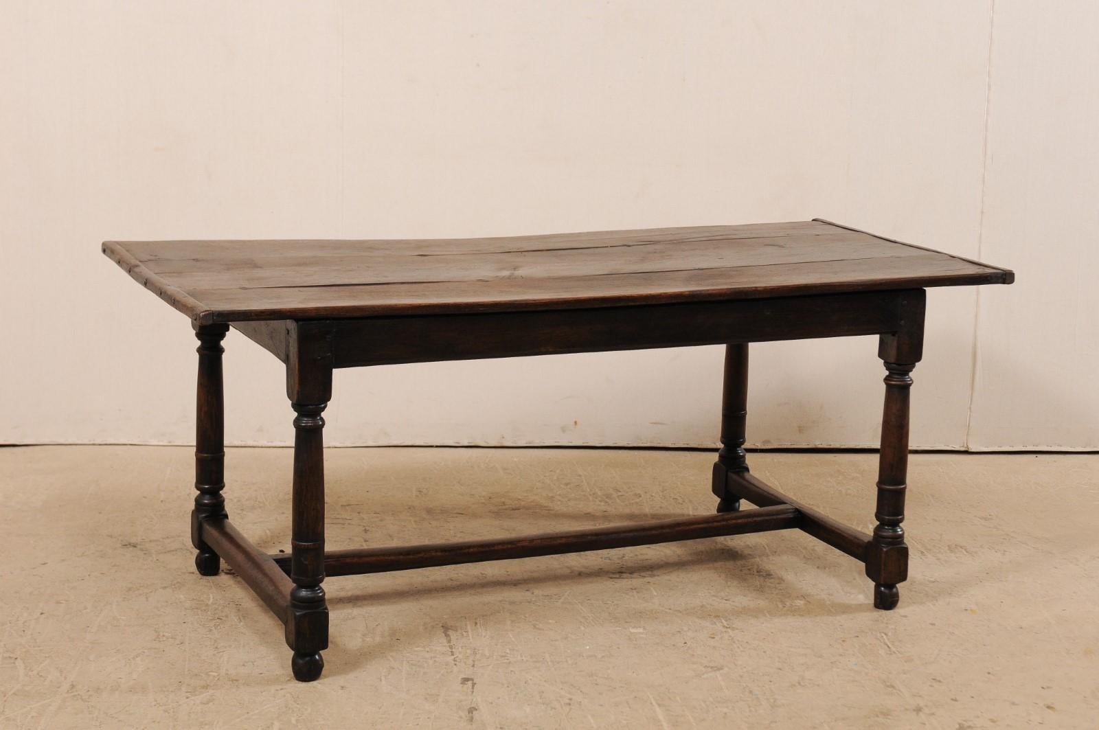 An early 19th century Italian dining table of walnut. This antique table from Italy has a rectangular-shaped top of lovely aged wood top, whose knots and grain add to the overall character of this piece, atop a plain skirt, and raised upon four