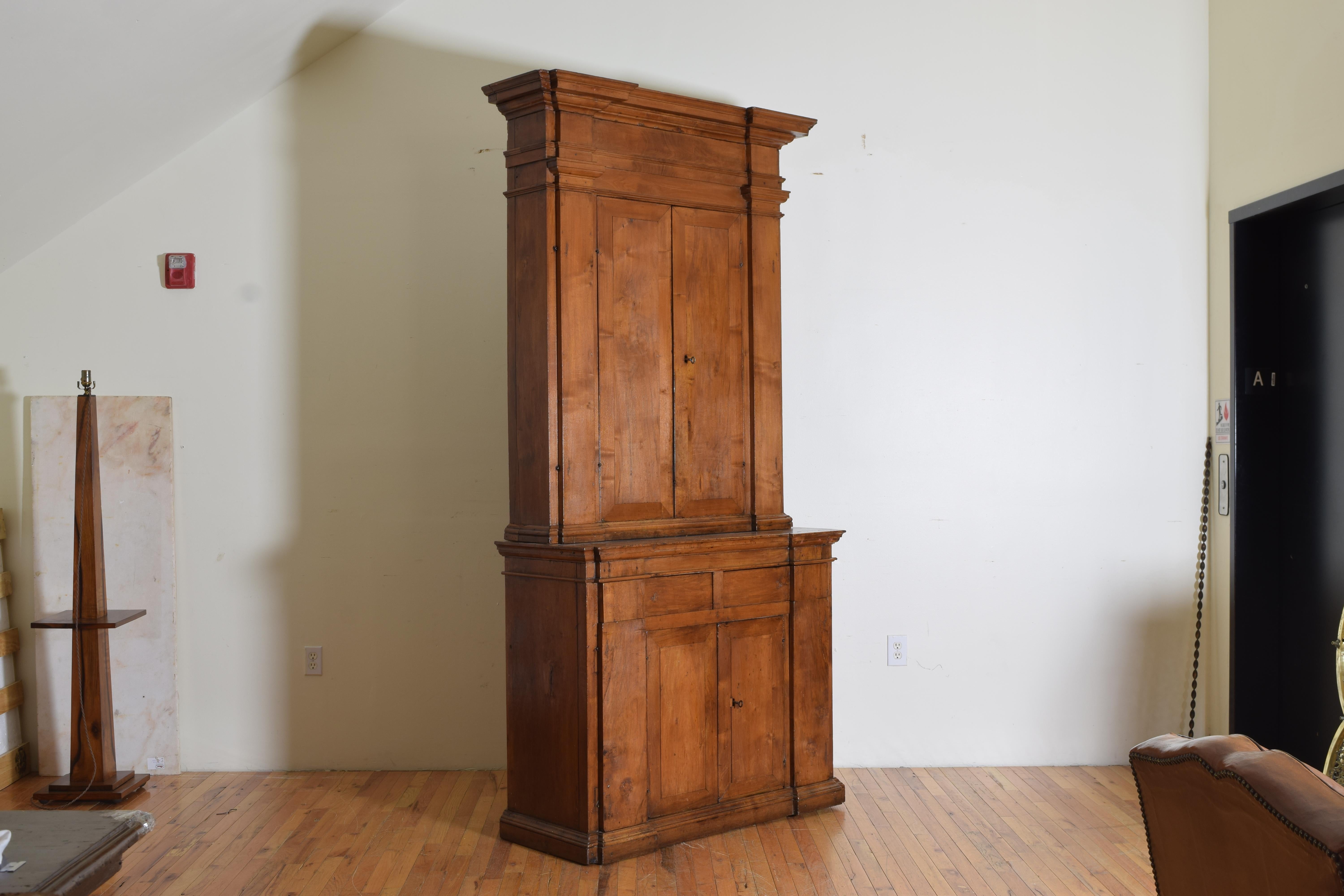 Hand Carved in light walnut and cleverly constructed for the many secretive spaces it hides. The top piece has two doors with interior shelves flanked by two panels that open to reveal more storage space. Below is a lower cabinet functioning the