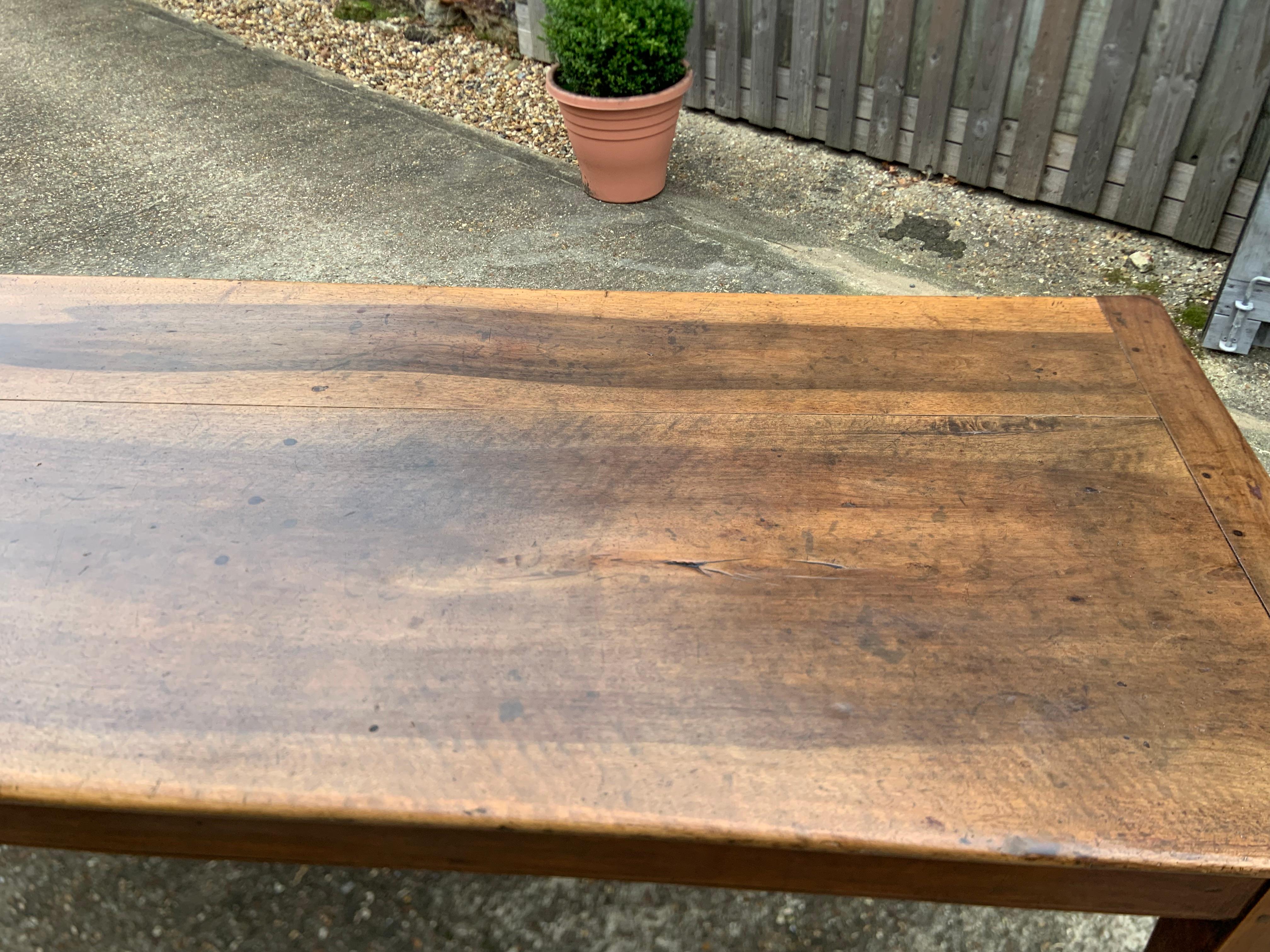 Antique walnut farmhouse table with two plank beautiful top and cleated ends with thick tapered legs and one end drawer. Gorgeous colour and patination.
 