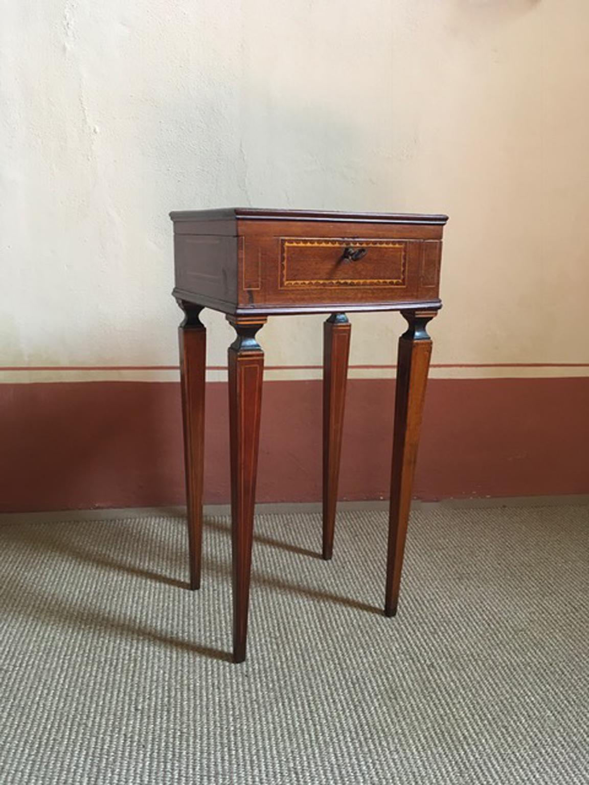 This elegant inlaid side table has the openable top, to contain, in the past, the sewing accessories.
Finely inlaid in oak tree and larch, coming from the Northern part of Italy. On the cover, there is a natural scene with two mountain