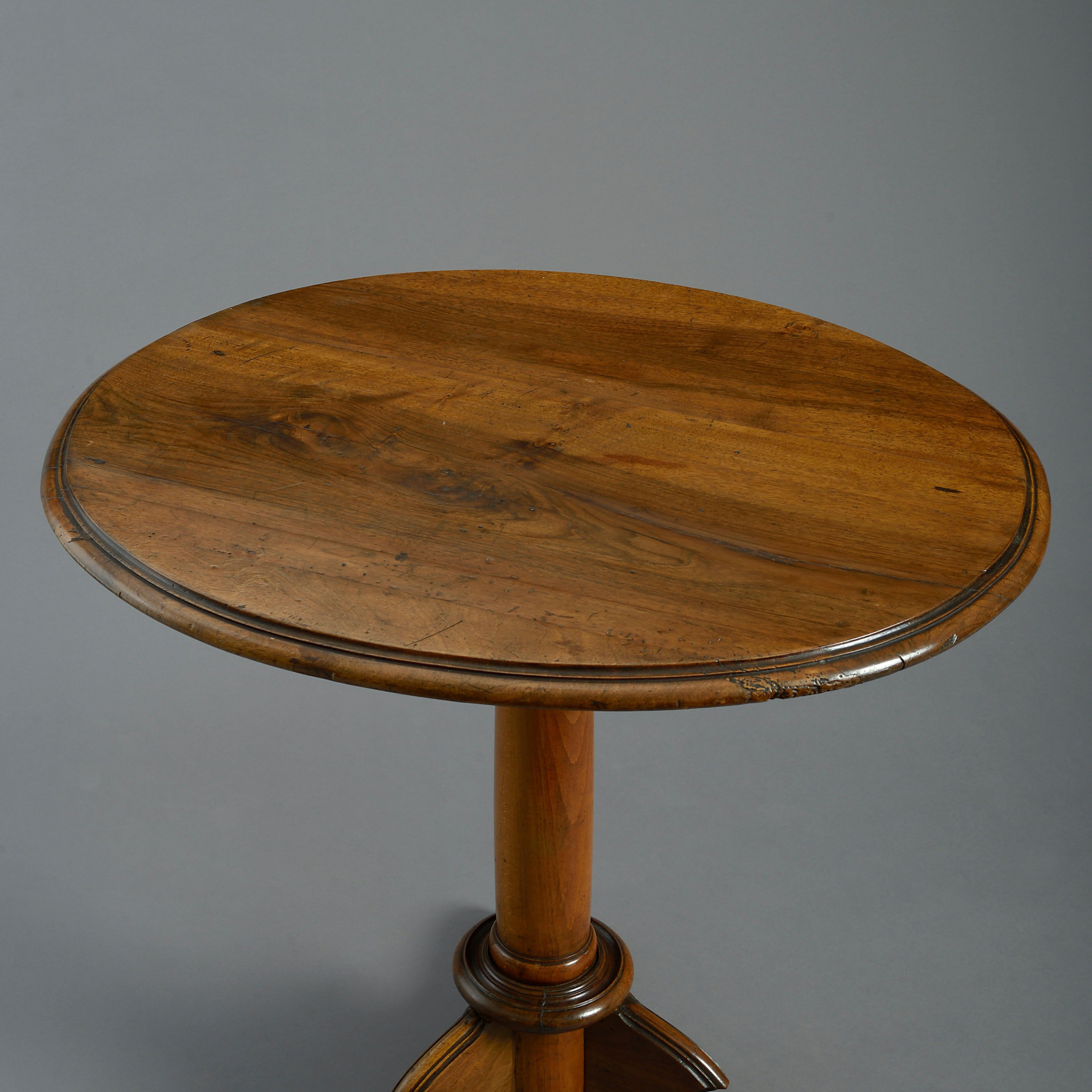 An early nineteenth century figured walnut occasional table, the oval top set upon a gun barrel stem and terminating in a shaped tripod base of scrolling supports.