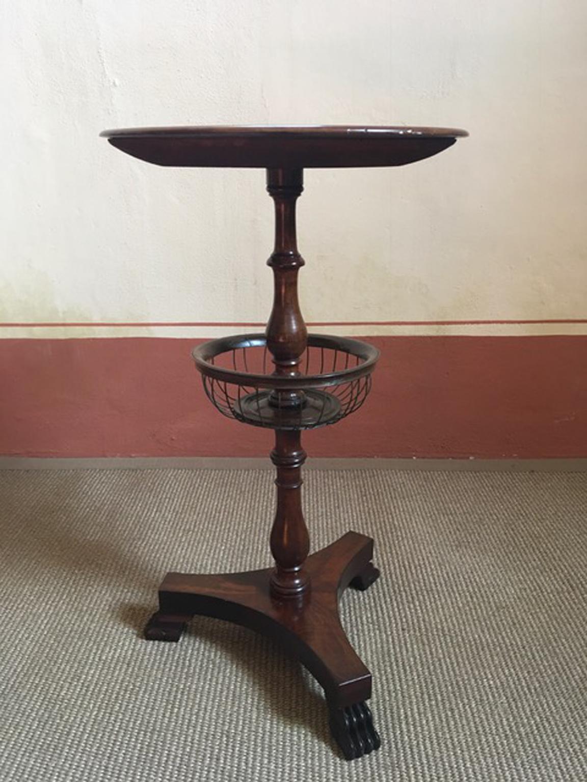This is an uncommon gueridon: it was used to contain the wool in the iron basket, when knitted.

The top is a whole piece of solid walnut, the central leg is hand carved in solid walnut and the feet at the base are in the shape of a lion's