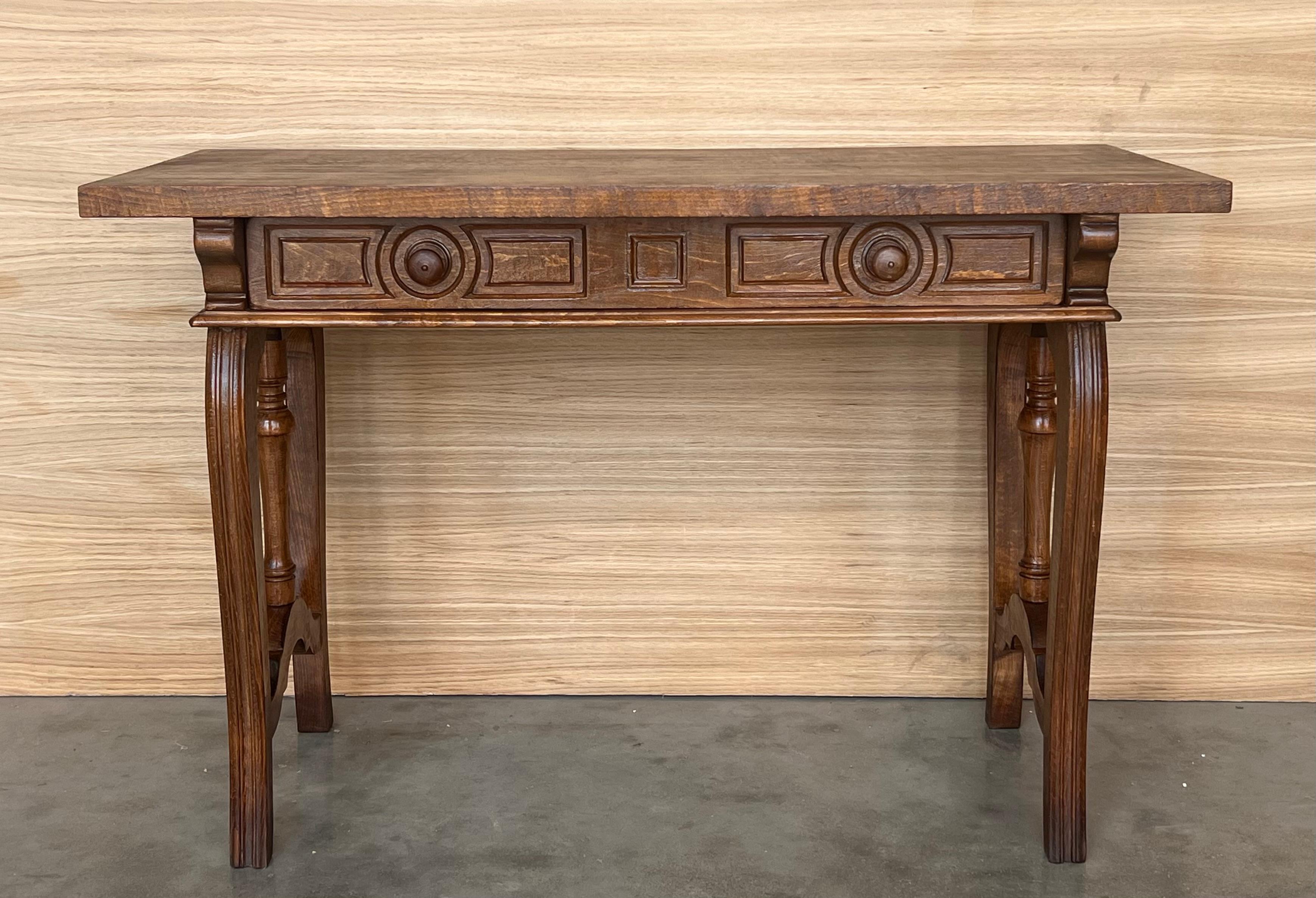 A 19th century walnut console table with a slab top above a frieze with two drawers with front decorated with and edge in each drawer and a single original iron pull . The table is supported on a hand carved base with fluted carved lyre legs joined