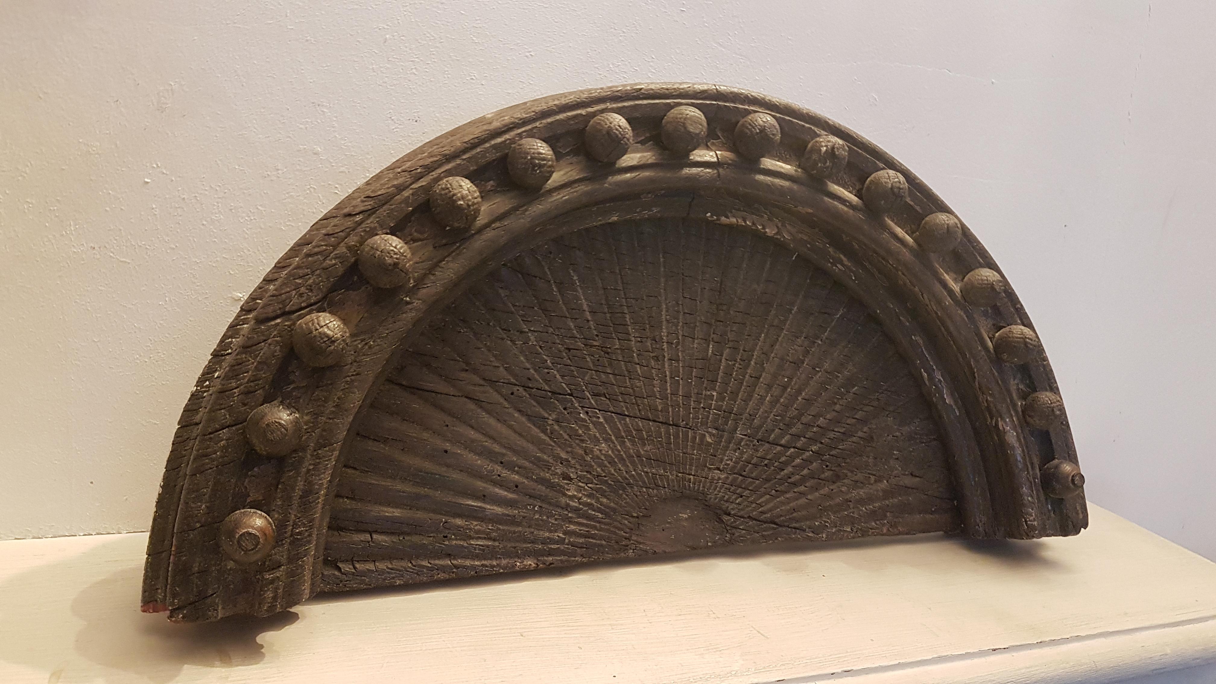This is a beautiful rustic architectural crest element most likely from a grand English country house furniture fitment. It is carved in oak and has traces of old paint around it that have survived what appears to be decades of weathering. The