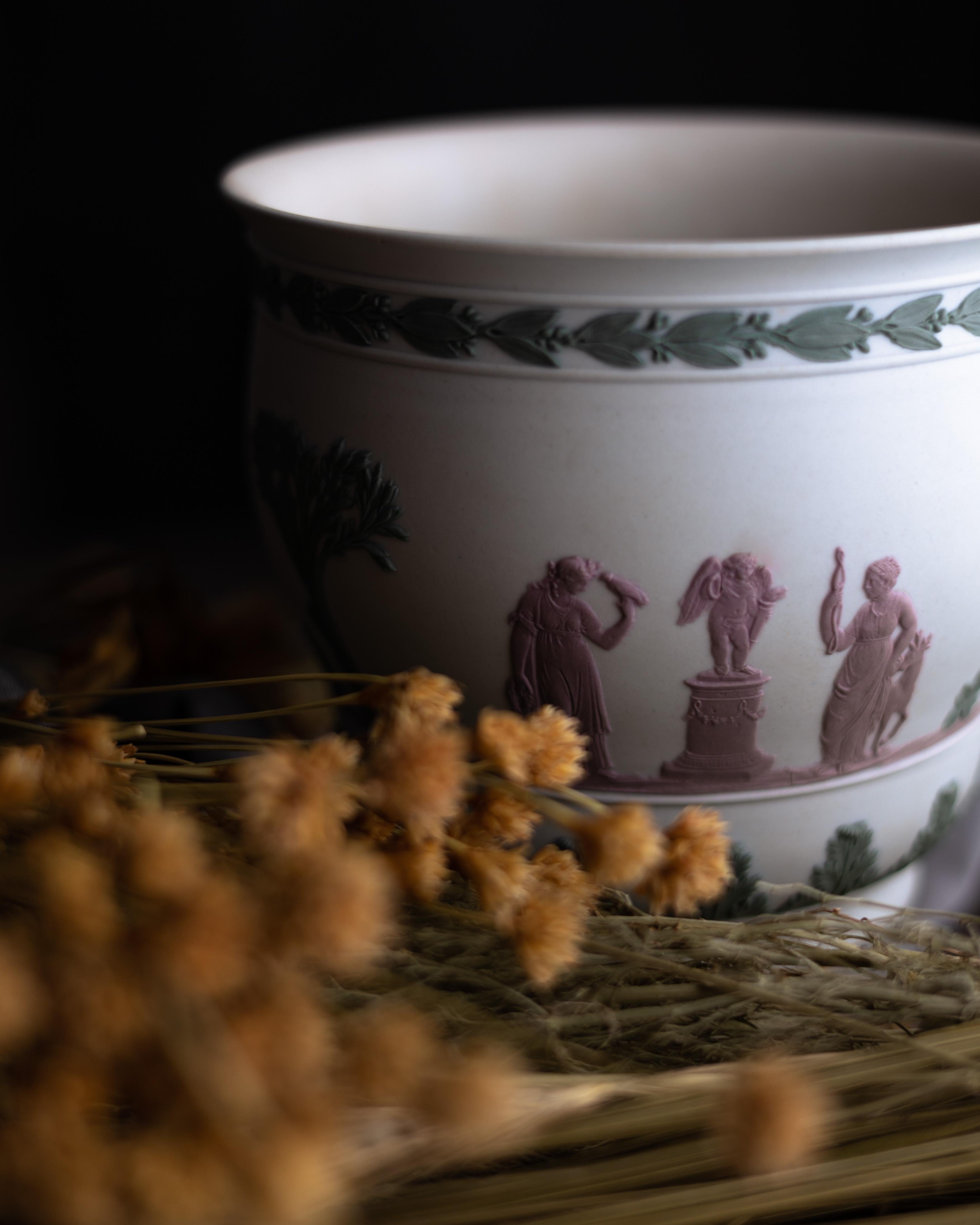 A Wedgwood jardiniere with lilac and sage details on a white jasperware ground.

Jasperware is perhaps the quintessential Wedgwood clay body and is even considered by some to be a ceramic development on par with porcelain. Originally developed in