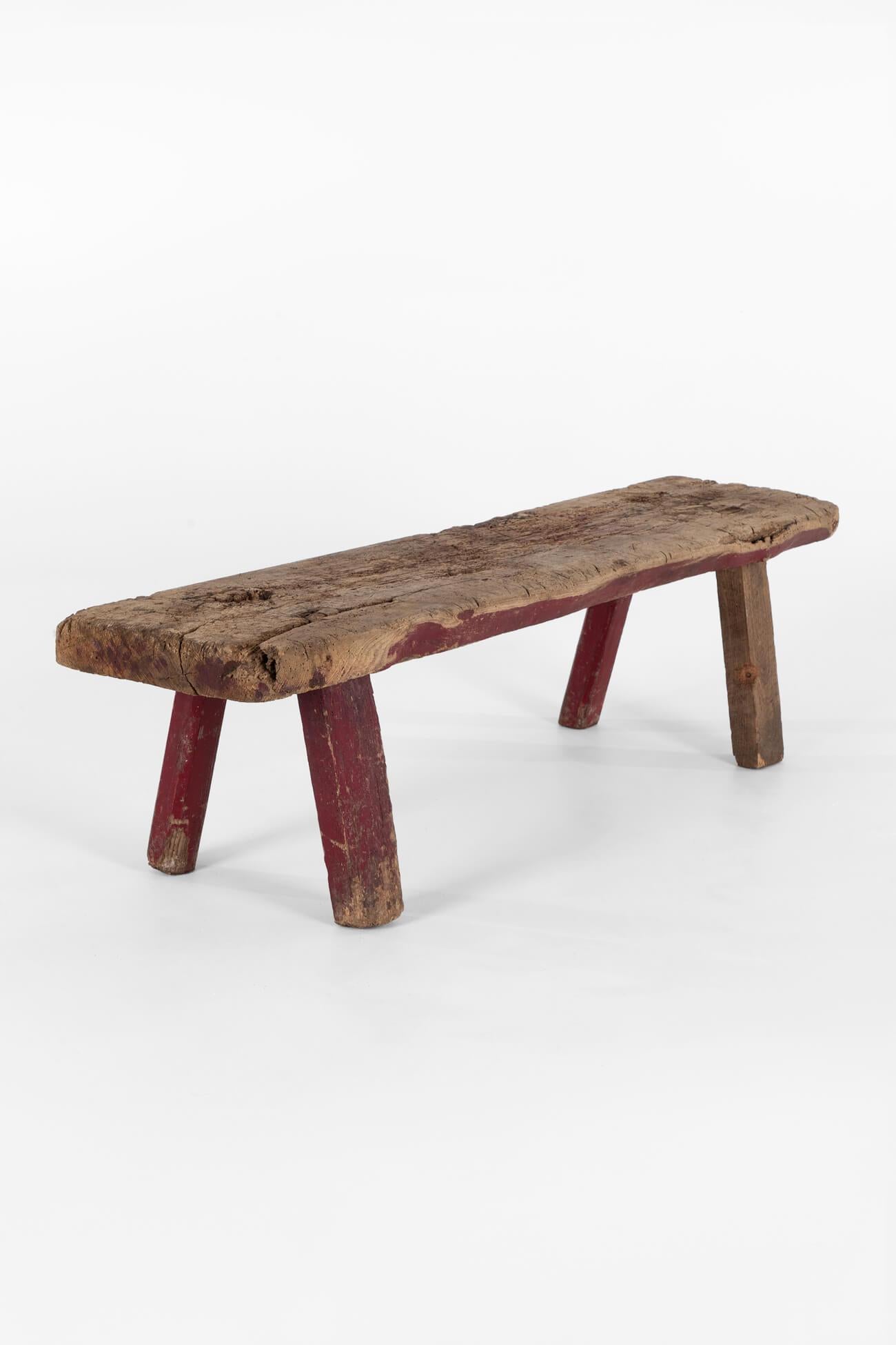 A weathered Welsh early 19th-century pig bench in elm.

Large single slab elm top over four square cut supports.

In original condition displaying heavy use and patination throughout with remnants of burgundy paint to the legs and sides.

Strong and