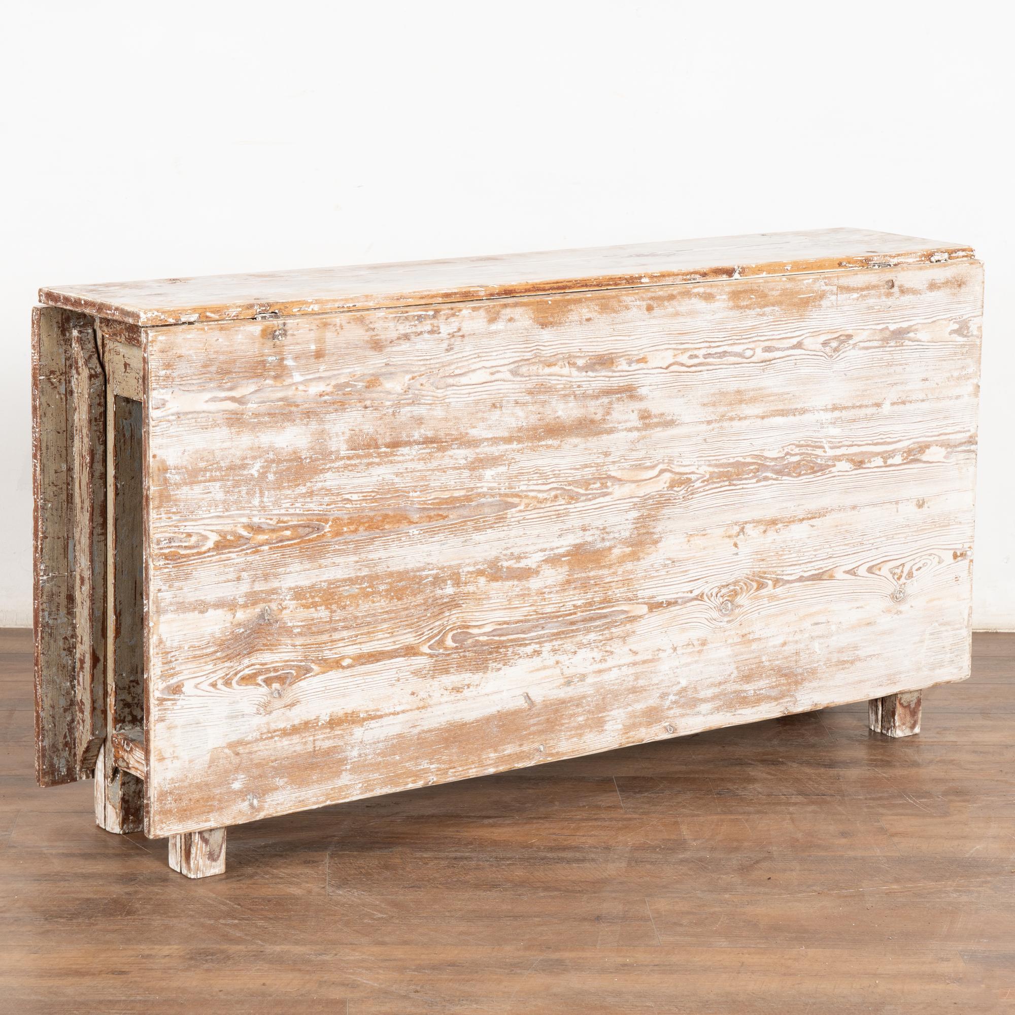 Dieser Tortentisch hat eine wunderbare Ausstrahlung, die durch das abgekratzte Finish der weißen Originalfarbe und die weiche, warme Patina des gealterten Kiefernholzes darunter entsteht.
Diese Art von Klapptisch war in Schweden weit verbreitet,