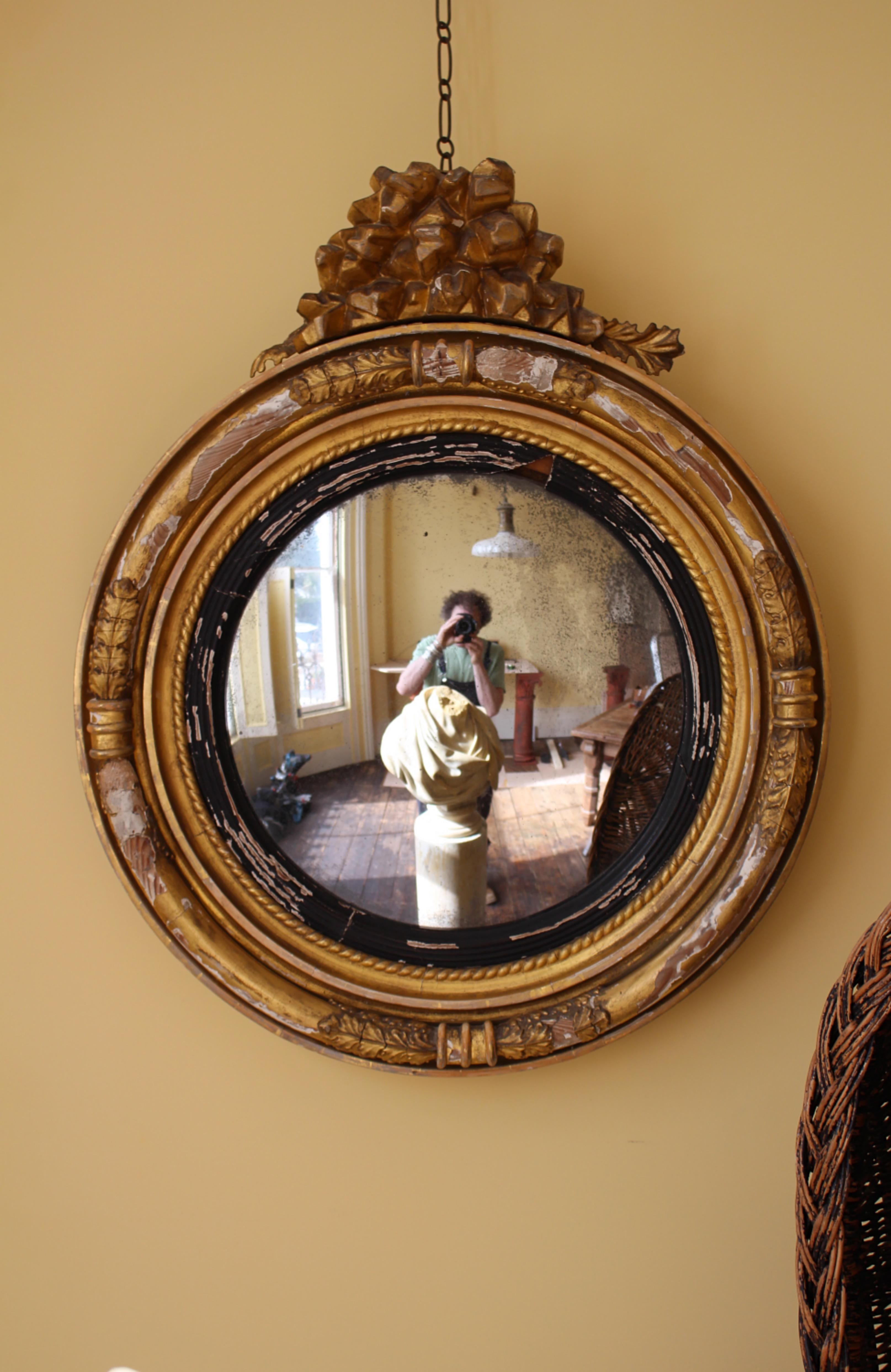 A good sized early 19th century gesso and gilt convex mirror, in unrestored original condition. With areas of loss, abrasions and scuffs. The original mirror plate has areas of oxidisation and pitting. 

Has a wonderful decorative, faded grandeur
