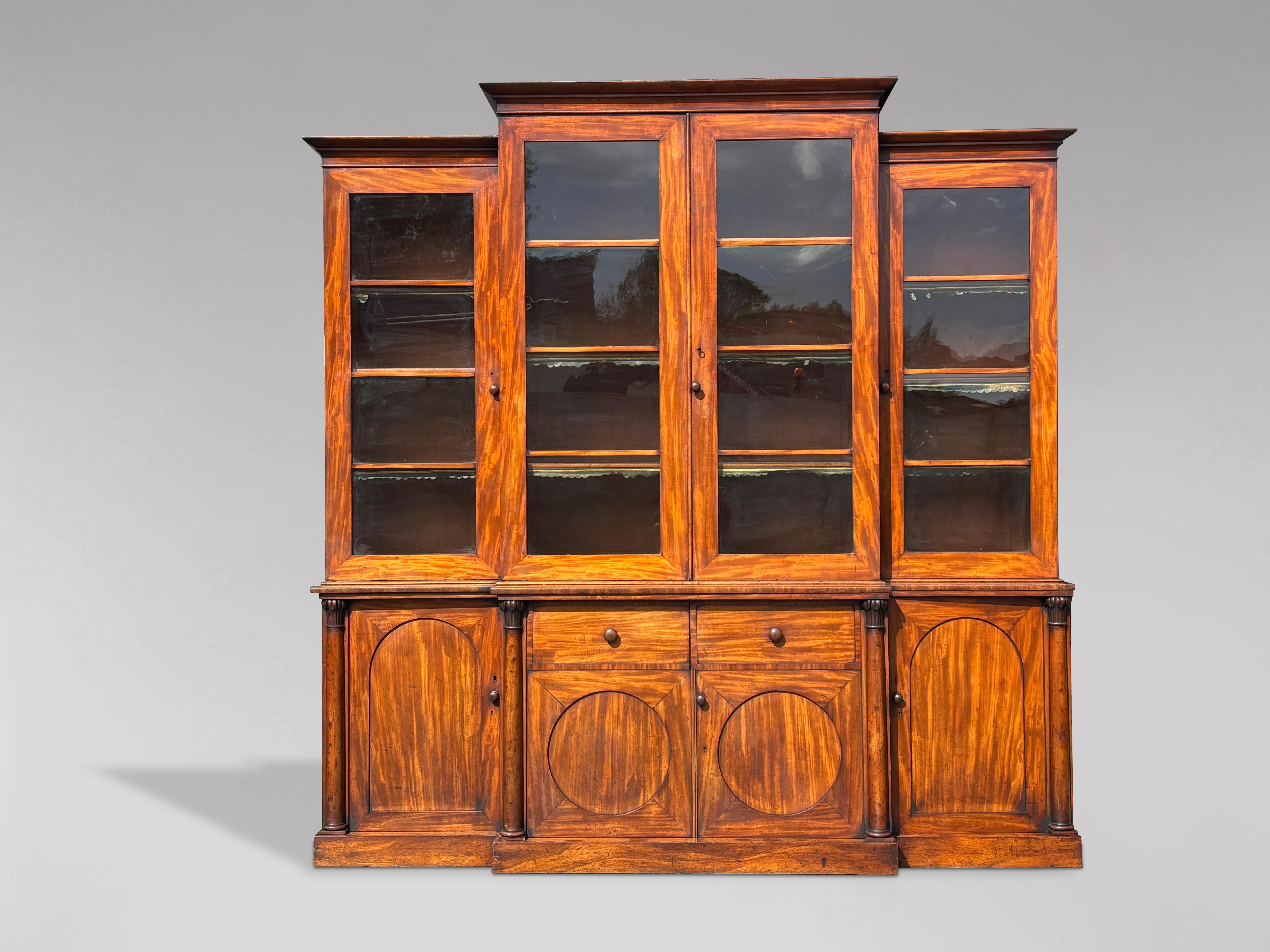 Una libreria a 4 ante in mogano fiammato dell'inizio del XIX secolo, intatta, di William Williams. Presenta un cornicione quadrato, modellato e a gradini, che sovrasta quattro porte con vetri astragali che racchiudono ripiani regolabili. La sezione