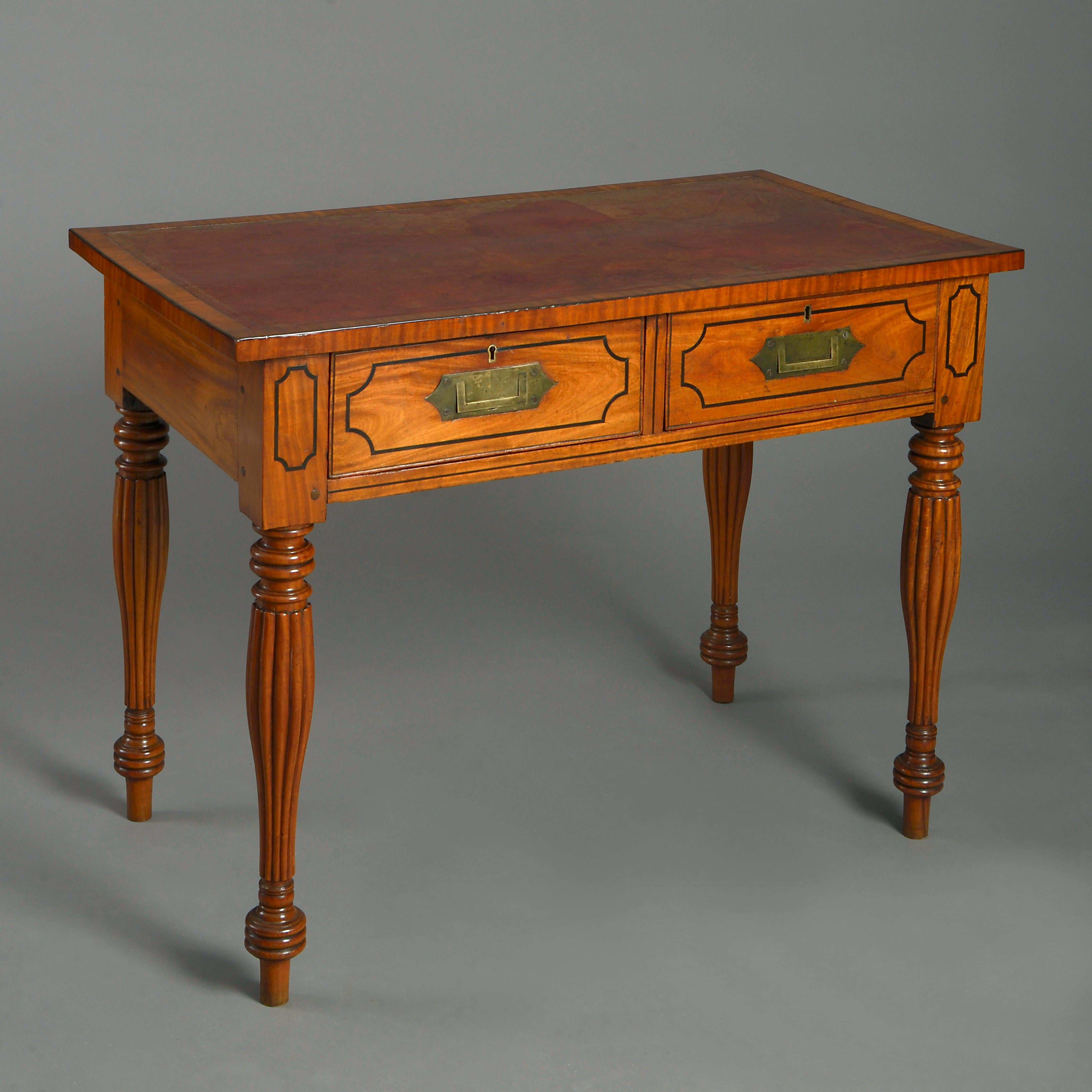 An early 19th century Anglo-Ceylonese satinwood Campaign desk, the original red leather top inset above two short drawers with ebony stringing and sunken brass handles and raised upon generously turned and fluted legs.

        