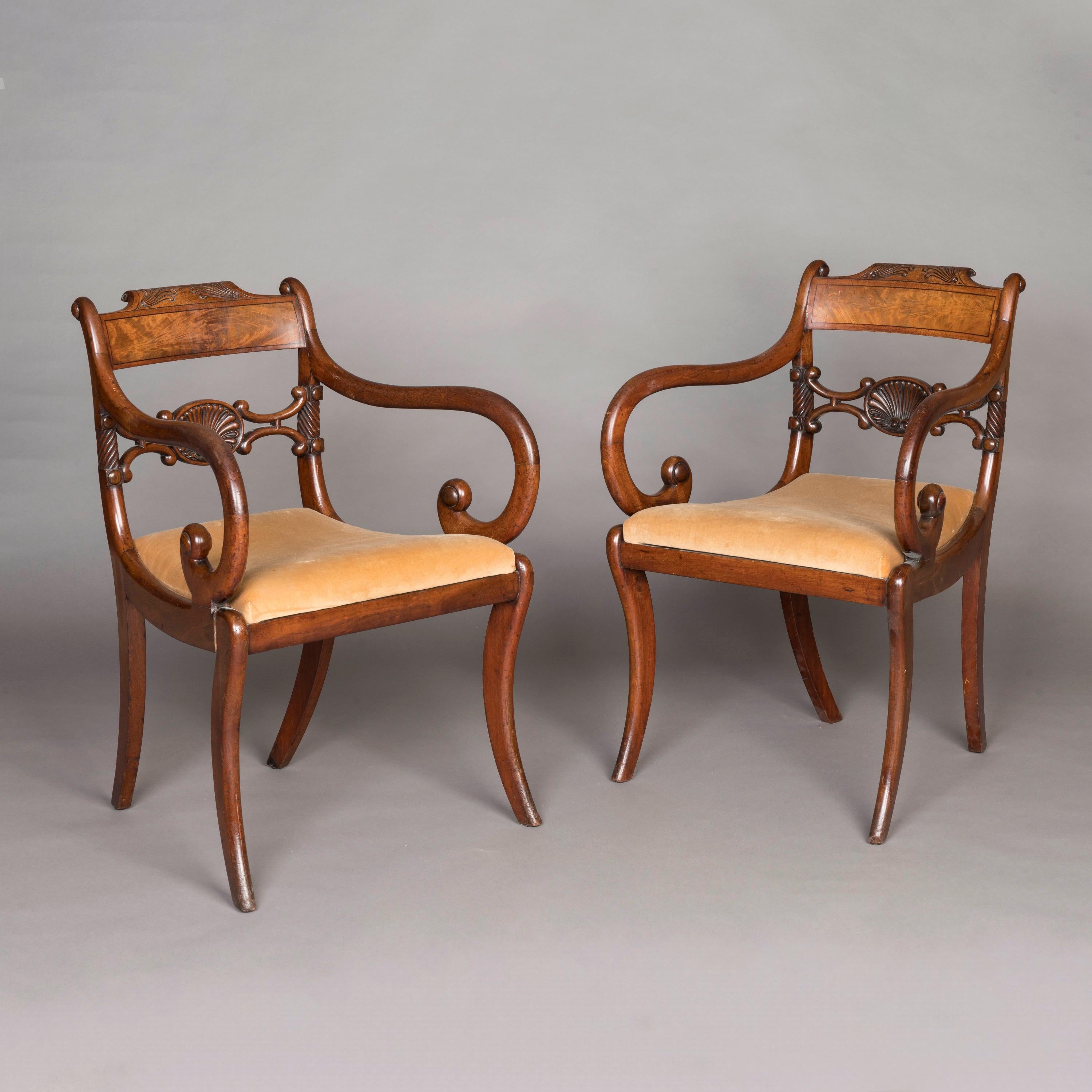 A Pair of Elegant Regency Armchairs

Constructed in mahogany, rising from sabre form front legs, bold 'C' scroll arm with roundels, the centre splat having a central shell flanked by 'C' inverted brackets with rope twist terminals to the stiles, the