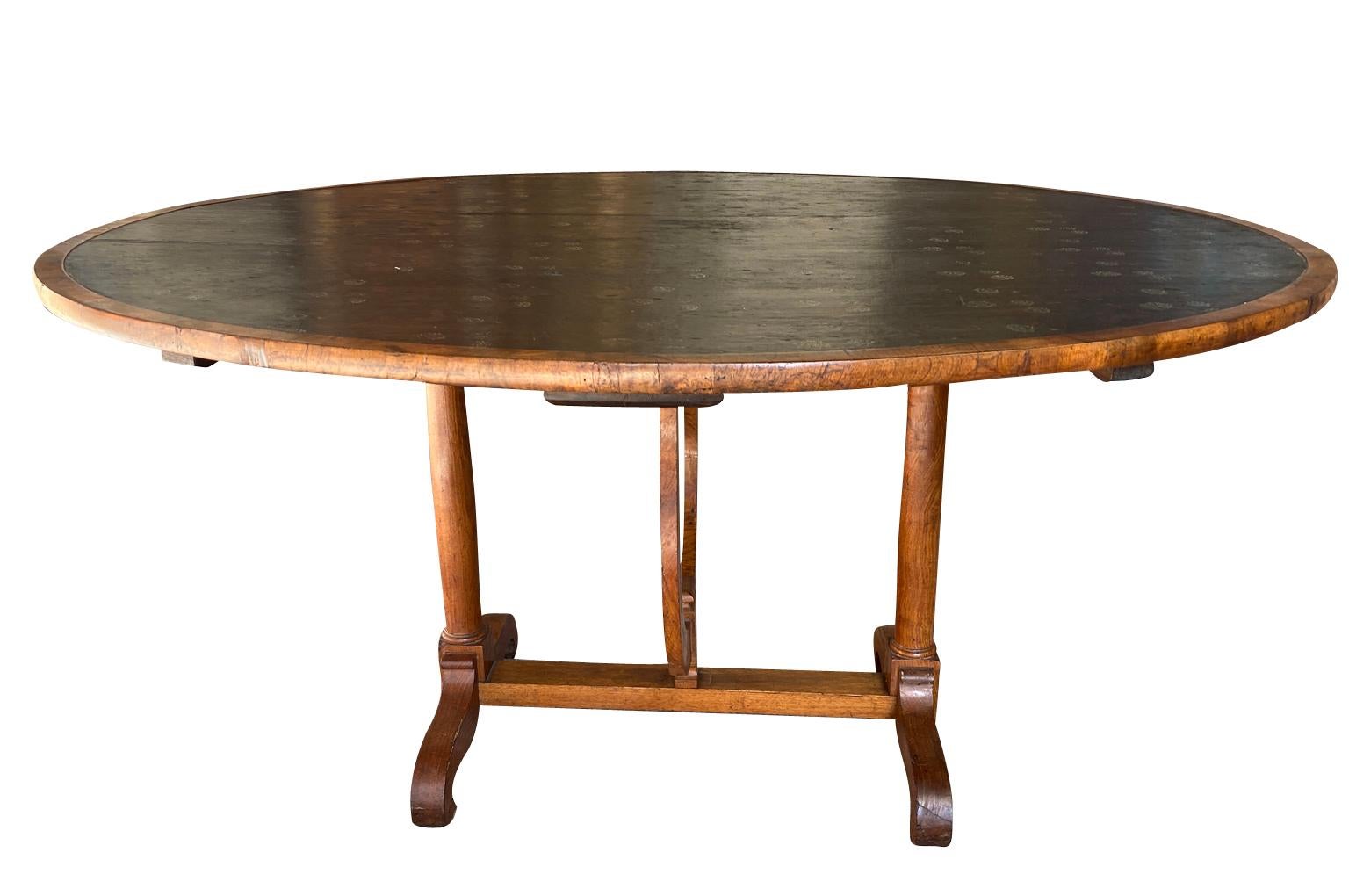 A very lovely early 19th century Oval Shaped Wine Tasting Table - Table Vigneron from the Provence region of France.  Beautifully constructed from walnut with a moleskin top and wonderful pivoting base.  Great patina.