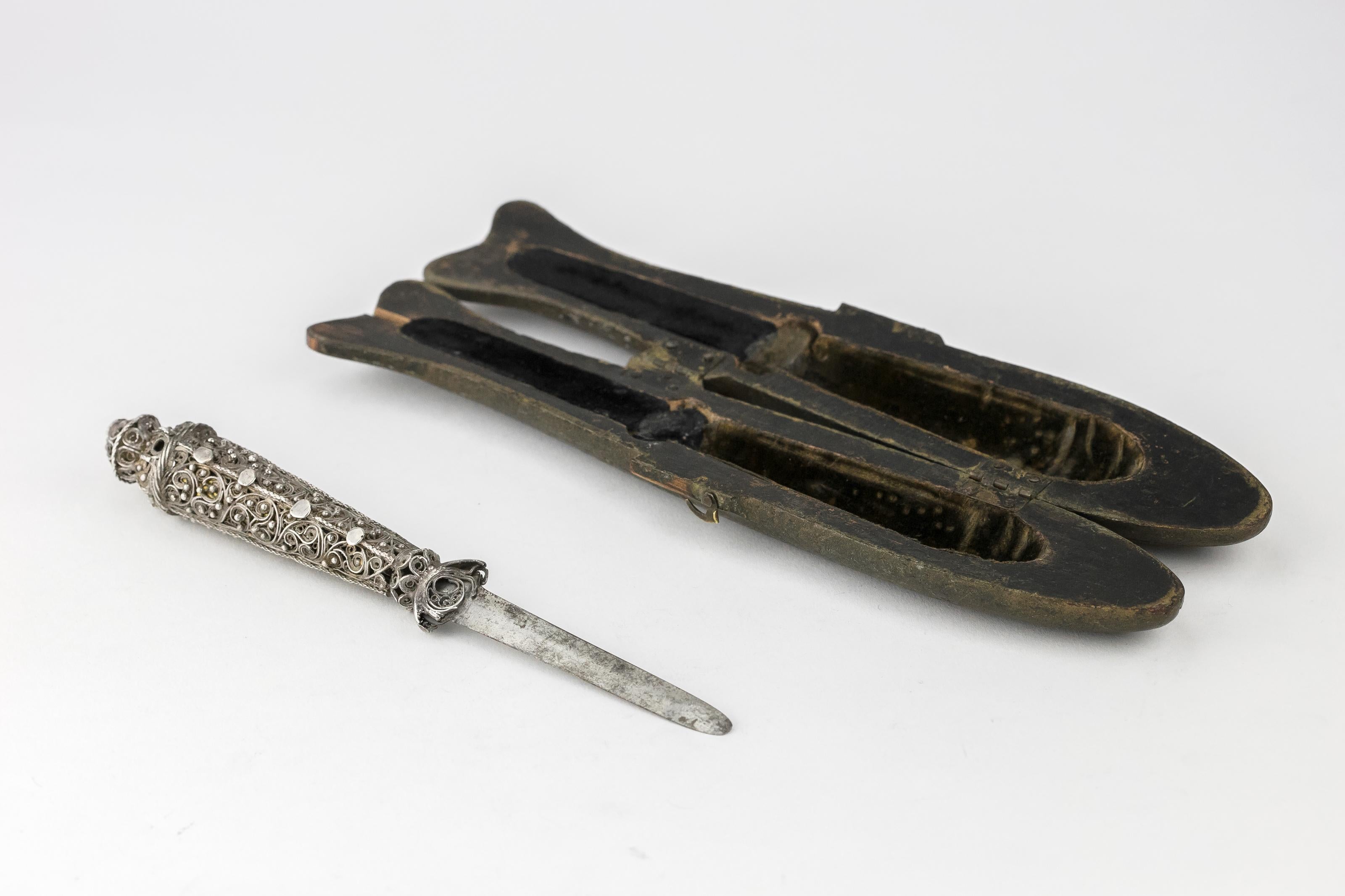 Circumcision knife in the original case. Galicia, early 19th century, circa 1810.
Filigree silver; steel; wooden case; velvet lining. Knife with a handle made of silver filigree and granulation. At the tip of the handle is a ball set with a red