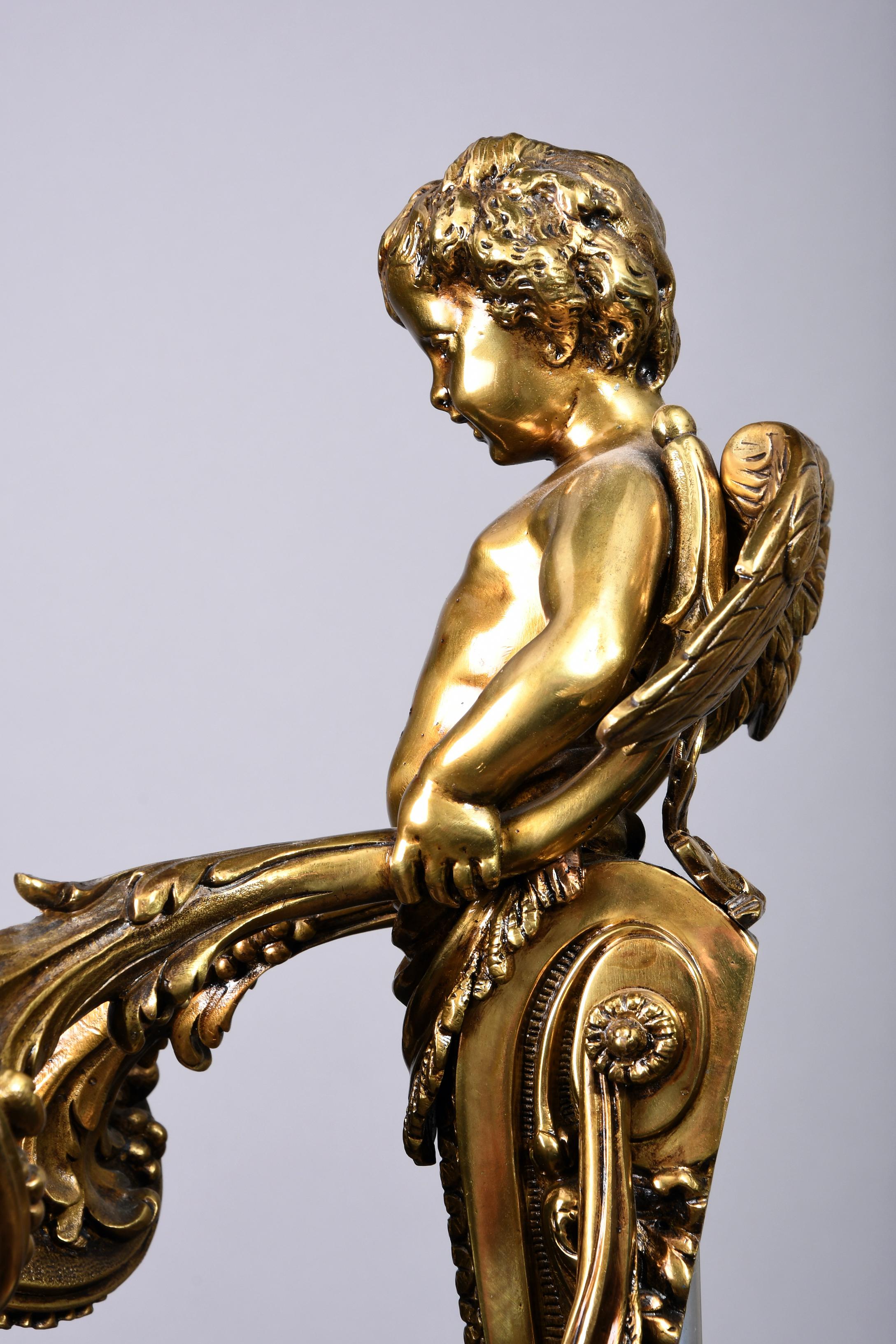 Pair of heavy solid bronze electrical sconces with a relieve decoration of acanthus leaves and swags that stand out the very shiny surface of the bronze. Very well done highlighted feathers originate from the back of the cherub. From the hands of
