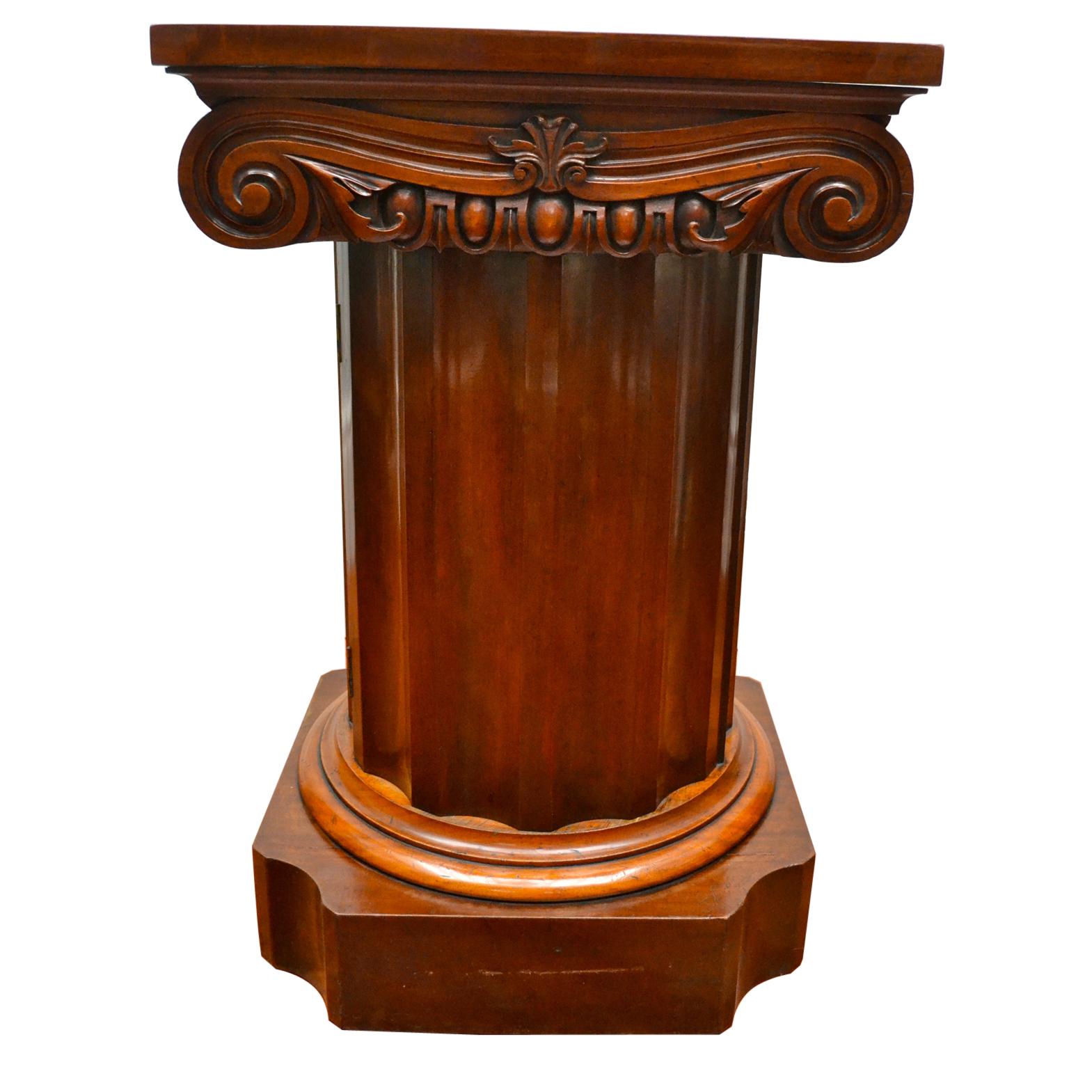 A fine example of neoclassical English Regency furniture. The pedestal cupboard is made of the highest quality Honduran mahogany. The round fluted column rests on a shaped rectangular base and is topped with a Corrinthian capital on three sides.