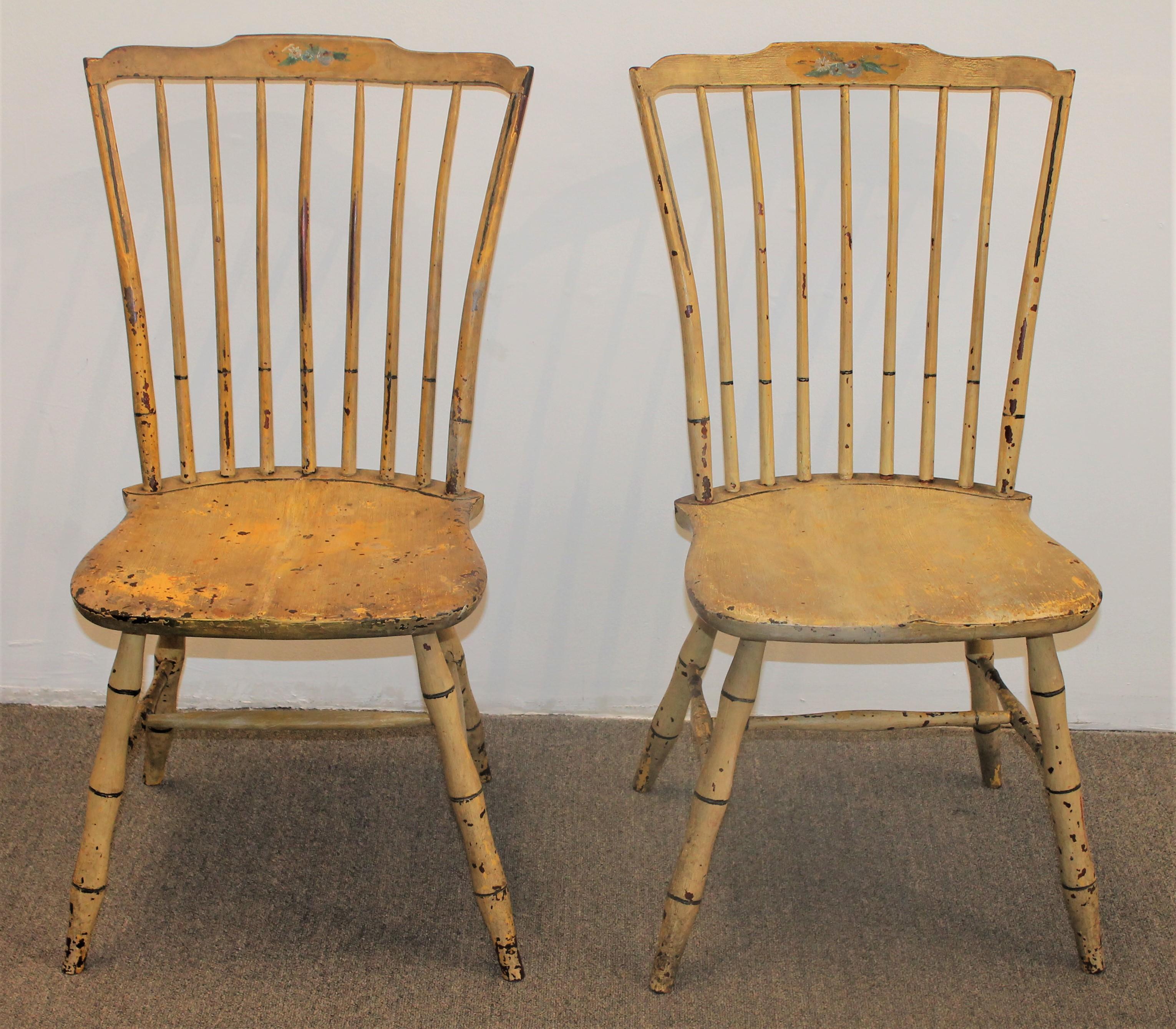 These fine early original yellow painted New England Windsor chairs are in good condition. They are paint decorated floral pattern on the front of the inside slat. They have minor paint loss throughout as seen in the pics with a nice patina surface