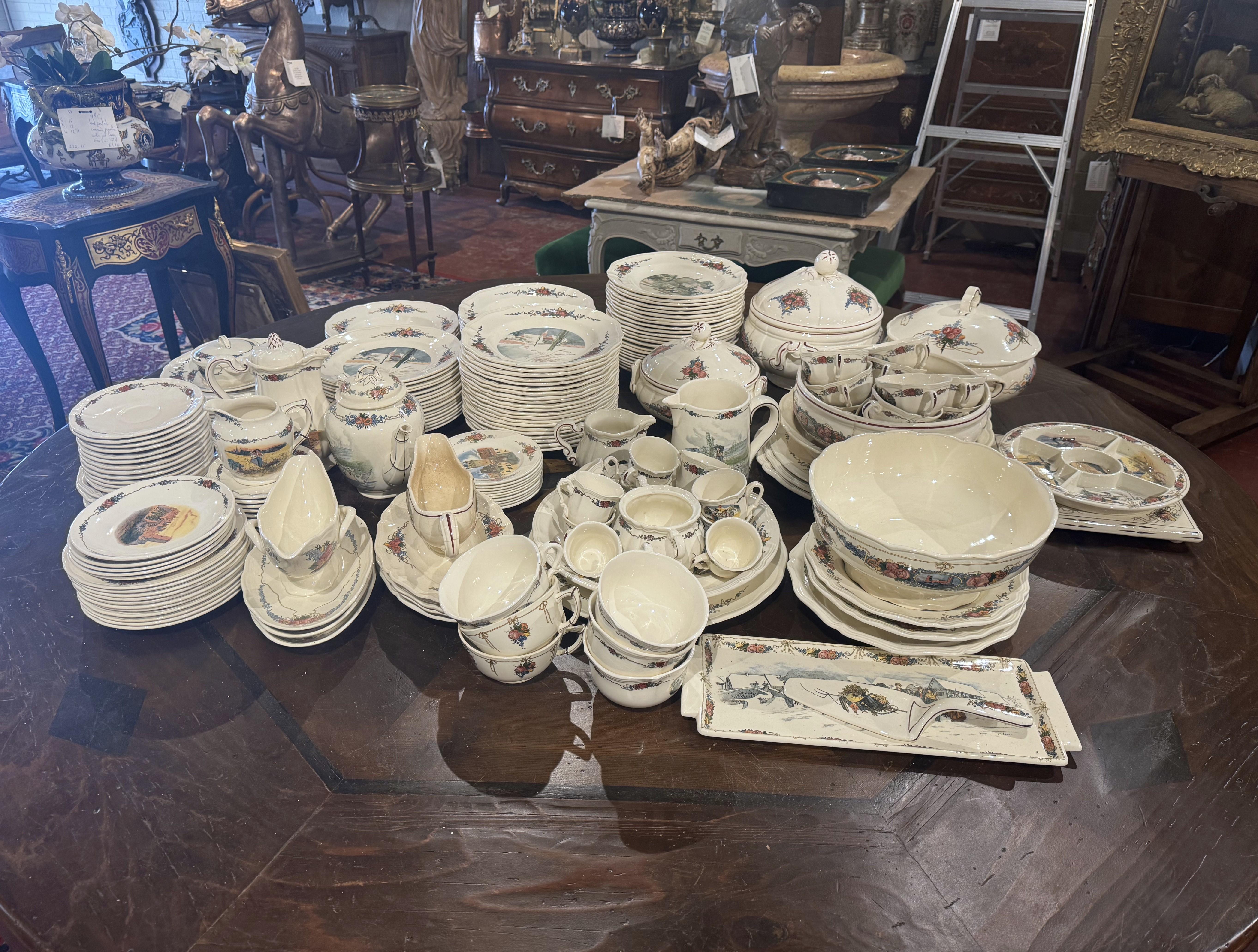Decorate a dining table or shelving with this antique porcelain service set of approximatrly 208 pieces. Crafted in France circa 1930 by Obernai Faïenceries Sarreguemines and signed by renowned artist H. Loux, each plate and dish features delicate
