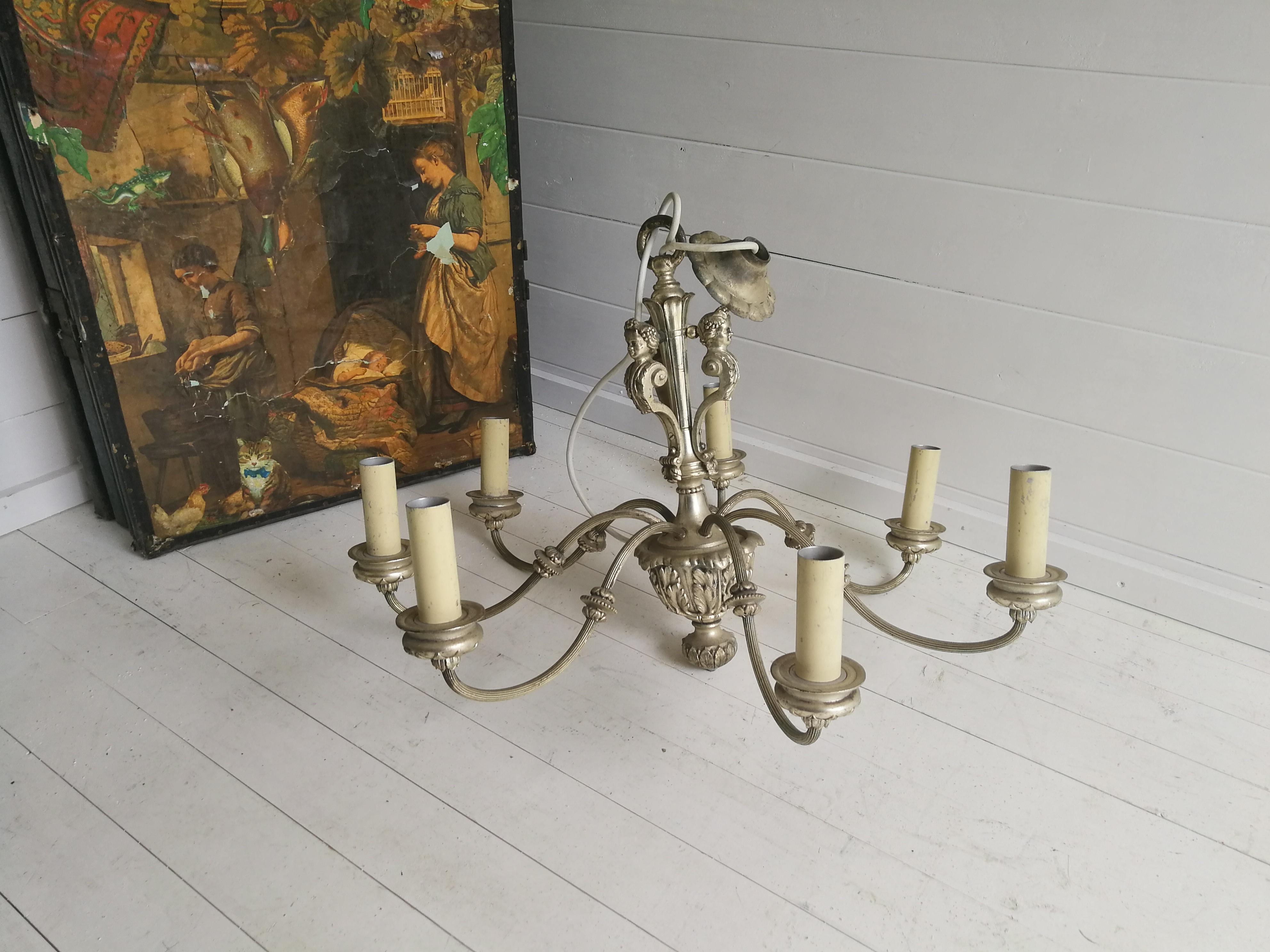 Stunning antique French Baroque style ceiling chandelier lamp with 7 arms with 3 cherub faces in its centre column.

Magnificent detail. 
Exceptionally fine and large, silver plated chandelier.
The upper section with putti over strongly scrolled