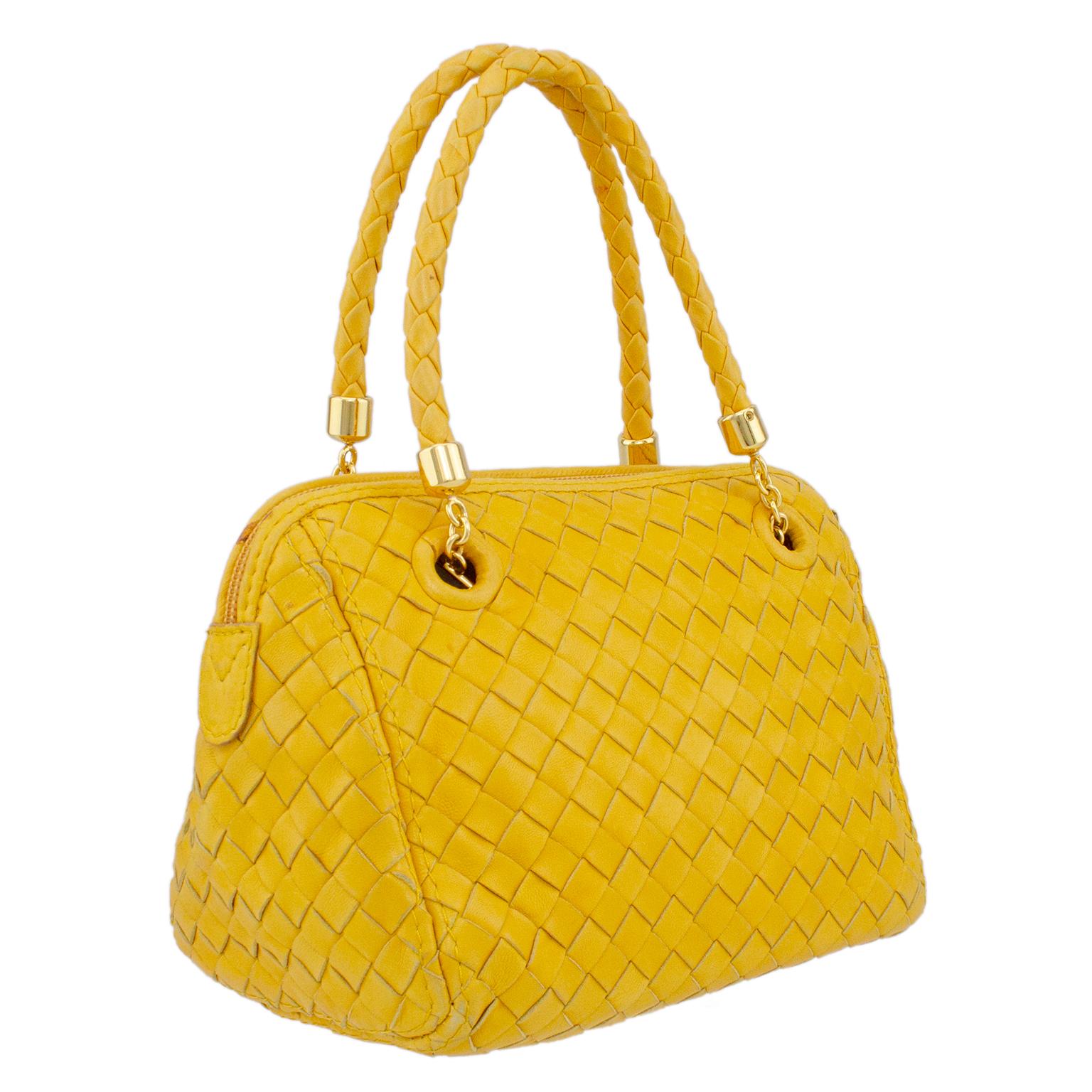 Very cute Bottega Veneta bag from the early 2000s. Mustard yellow leather, cut and weaved into the iconic Bottega intrecciato pattern. Matching top handles with gold tone metal hardware and a small tassel zipper pull. Tan leather interior with one