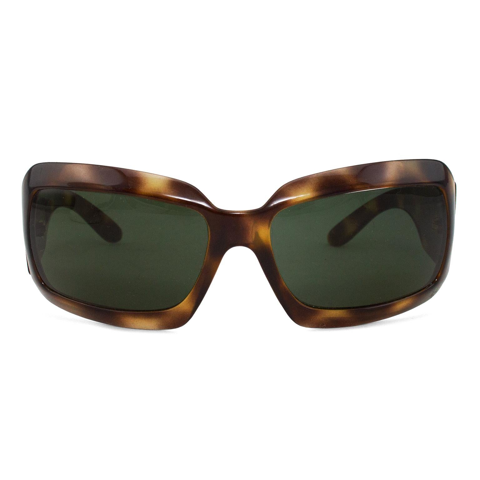 Chic brown tortoise shell sunglasses from the early 2000s. Slight wrap around style. Square lenses with rounded edges. Silver/grey mother of pearl large CC logo on arms. All other Chanel markings stamped in white on interior of arms. Black lenses.