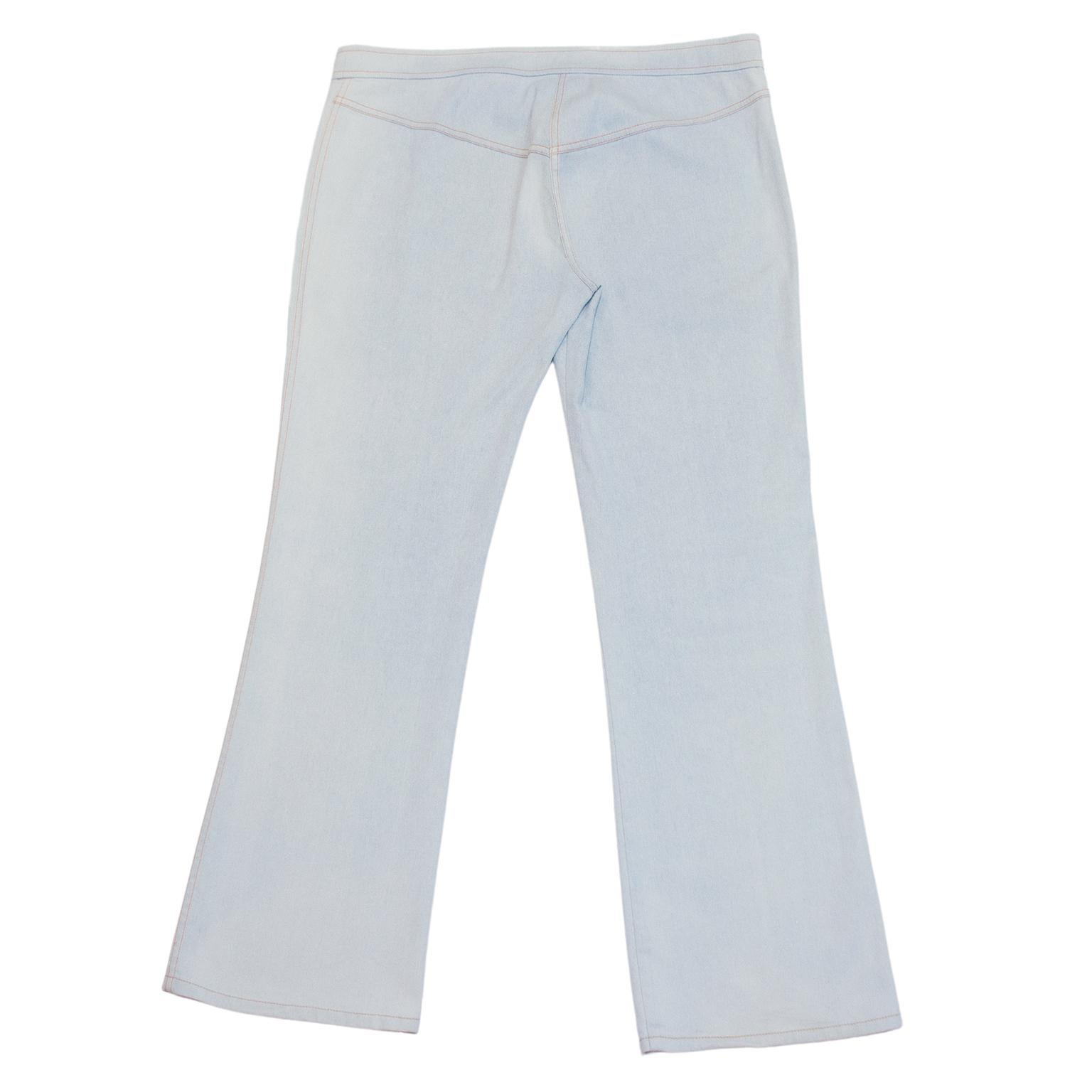 Christian Dior jeans designed by John Galliano in the early 2000's. Light blue wash with metallic silver throughout and contrasting orange top stitching. Faux button fly - zipper behind buttons. Low-is rise and boot cut. Rounded patch pockets at