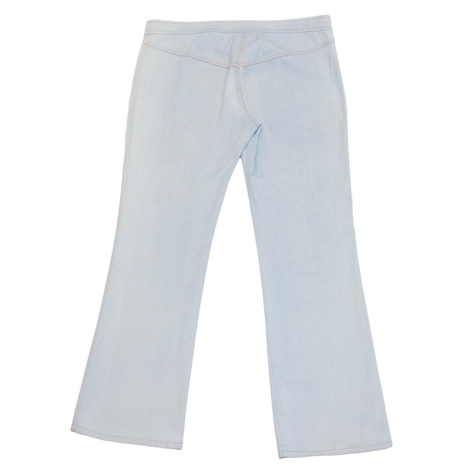 I jeans Christian Dior disegnati da John Galliano nei primi anni 2000. Lavaggio azzurro con argento metallizzato e cuciture arancioni a contrasto. Chiusura con finti bottoni - cerniera dietro i bottoni. Vita bassa e taglio a stivale. Tasche
