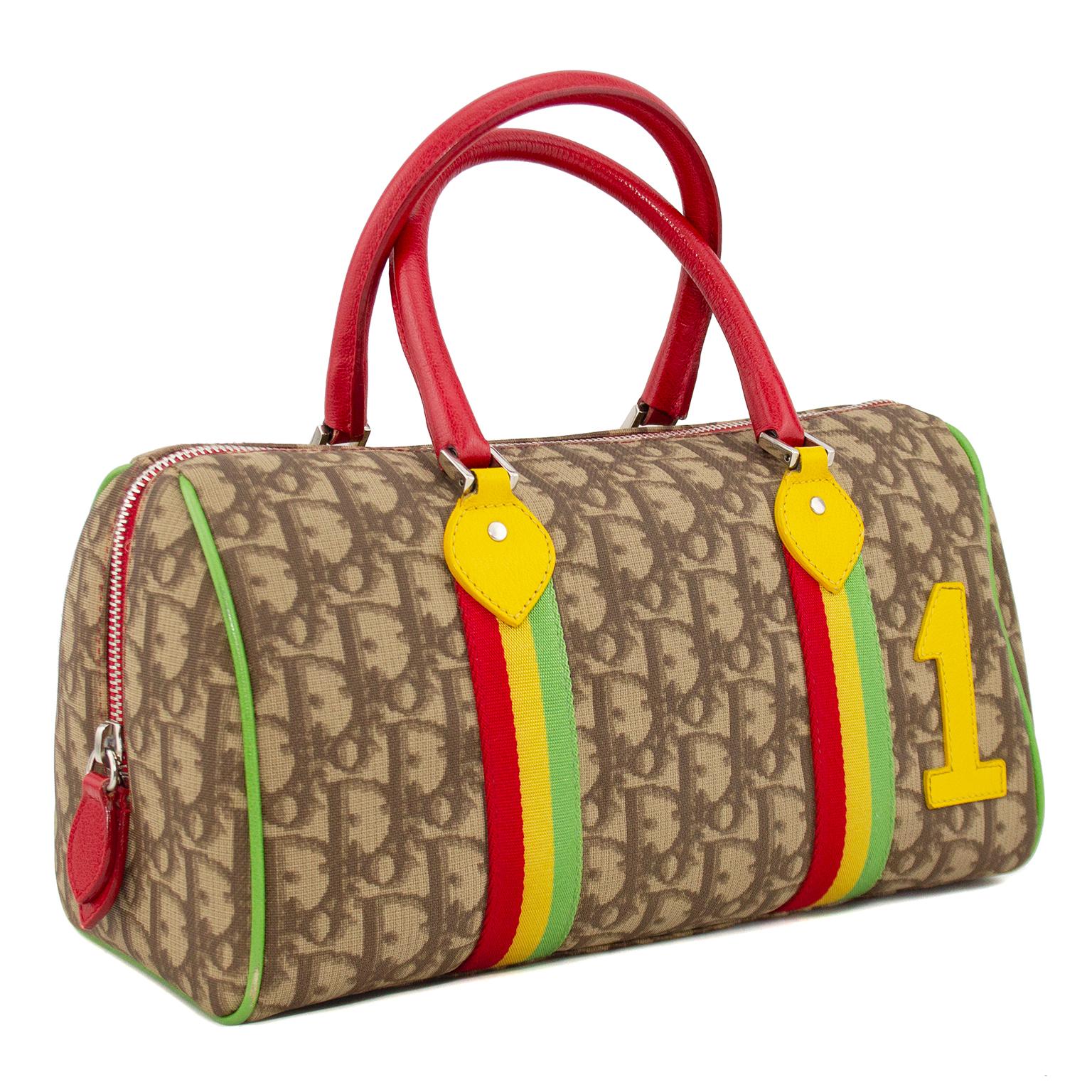 Christian Dior Boston bag from the early 2000's Rasta collection. Crafted from Christian Dior's signature DIOR printed canvas with Rasta inspired red, gold and green front stripes, red leather handles, green leather piping, yellow leather number 1,