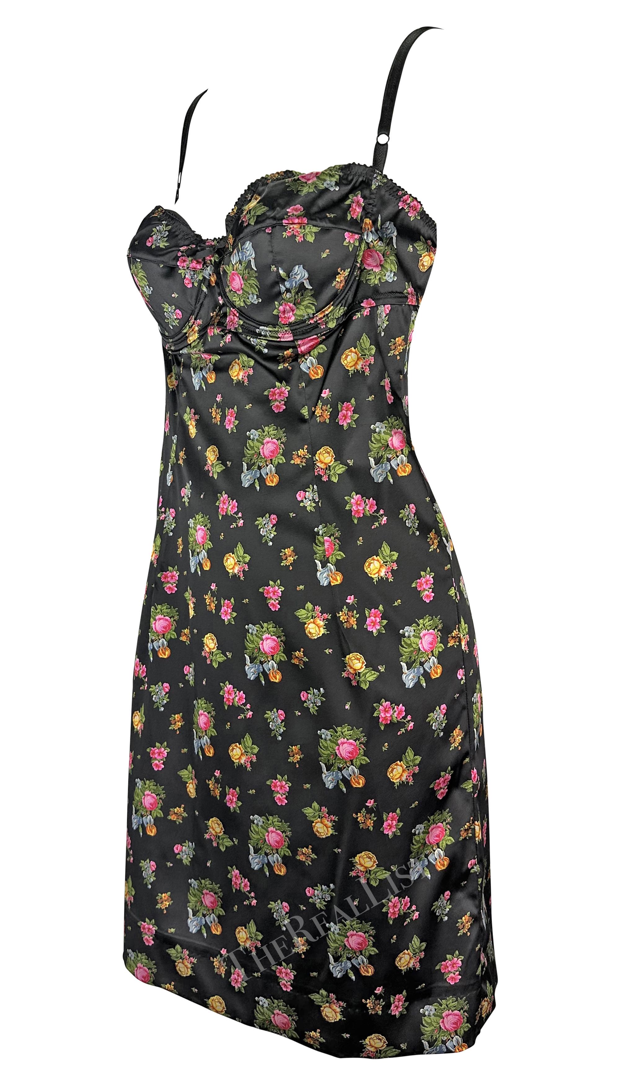Presenting a fabulous black floral Dolce & Gabbana mini dress. From the early 2000s, this form-fitting black dress features a multicolor rose print. The dress is made complete with an outlined bust lending to a lingerie-effect and thin strap. Fall