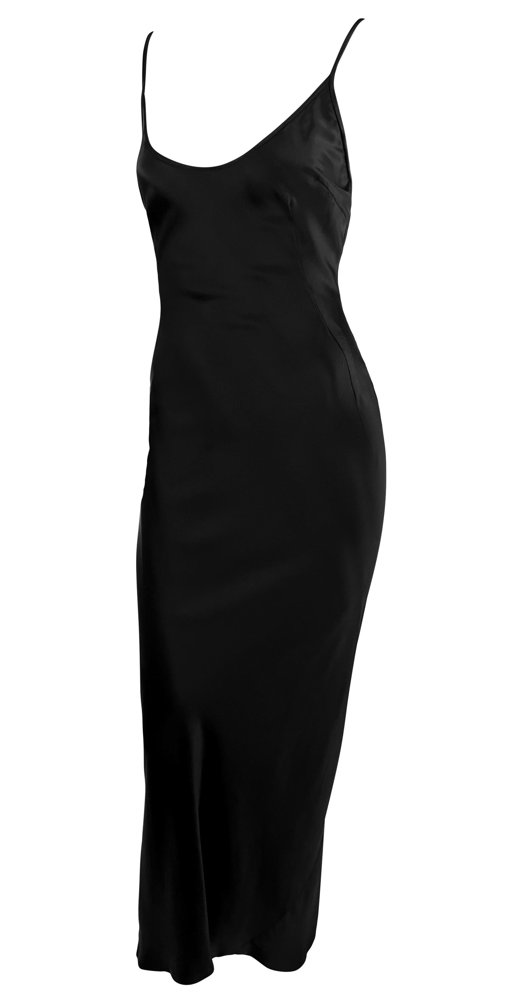 From the early 2000s, this sleek Dolce & Gabbana black silk satin slip gown is a simple and chic closet staple. This silky satin floor-length gown elegantly drapes over the body, featuring a scoop neckline, exposed back, and thin shoulder straps.
