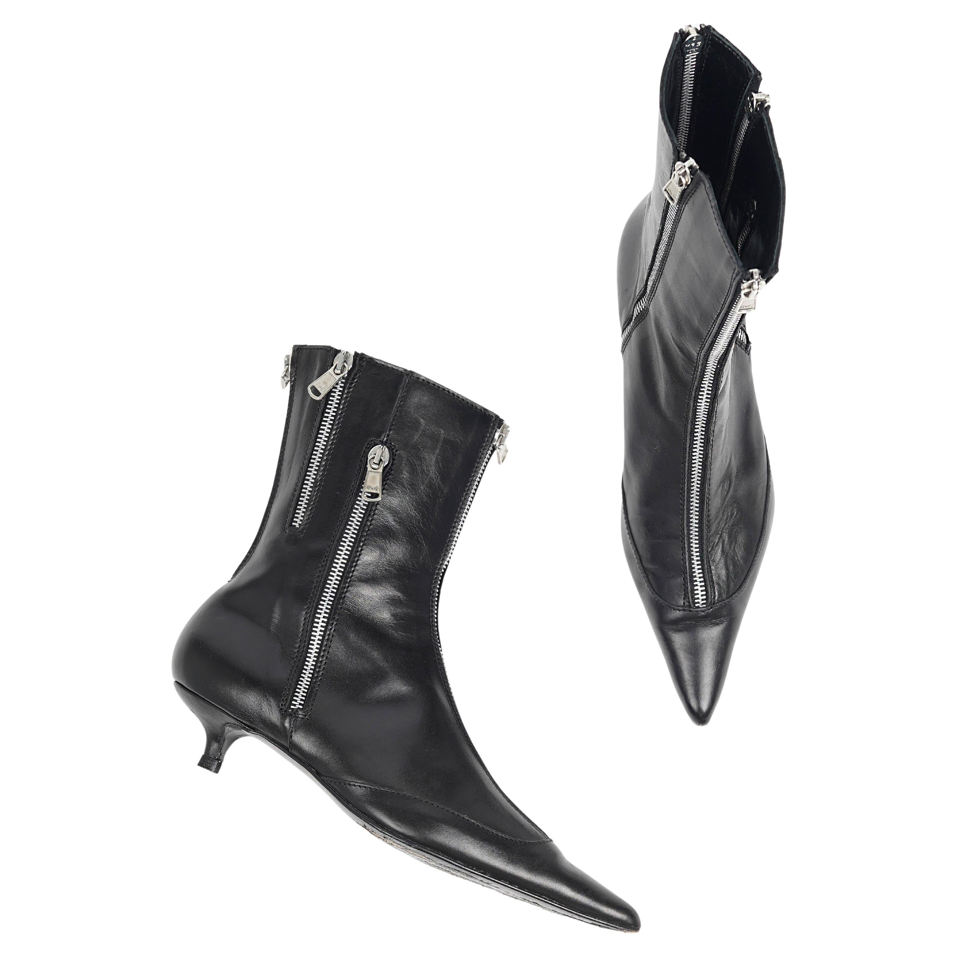 Estos esculturales botines de piel, un llamativo par de botas Dolce & Gabbana de principios de la década de 2000, presentan la estética vanguardista y glamurosa característica de la marca. Fabricadas en Italia con piel negra brillante, las botas