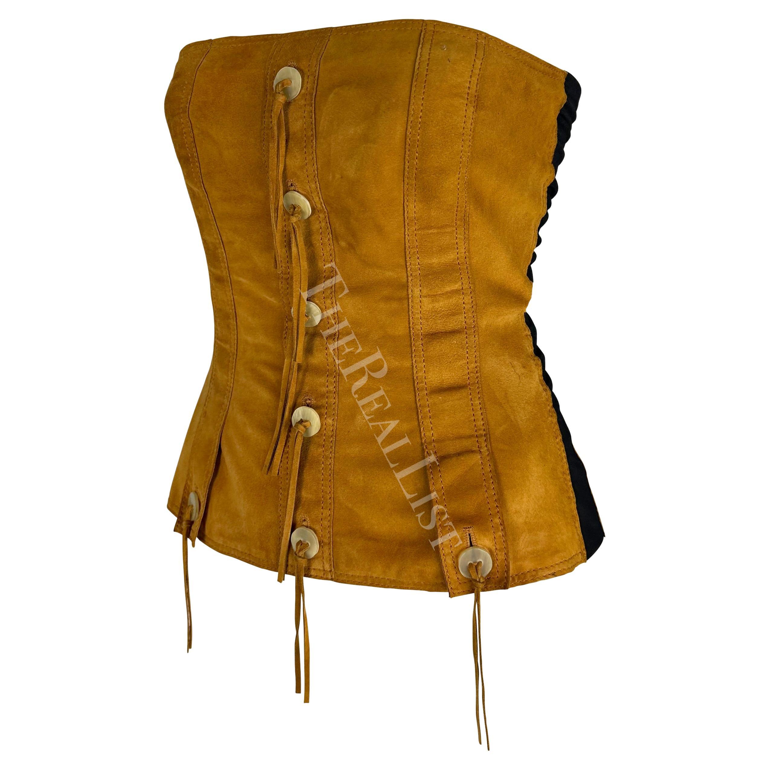 TheRealList presents: a tan suede Dolce & Gabbana strapless top. From the early 2000s this chic top is constructed of light brown suede with black sheer stretch panels on either side. The top is made of complete bone buttons and fringe accents.