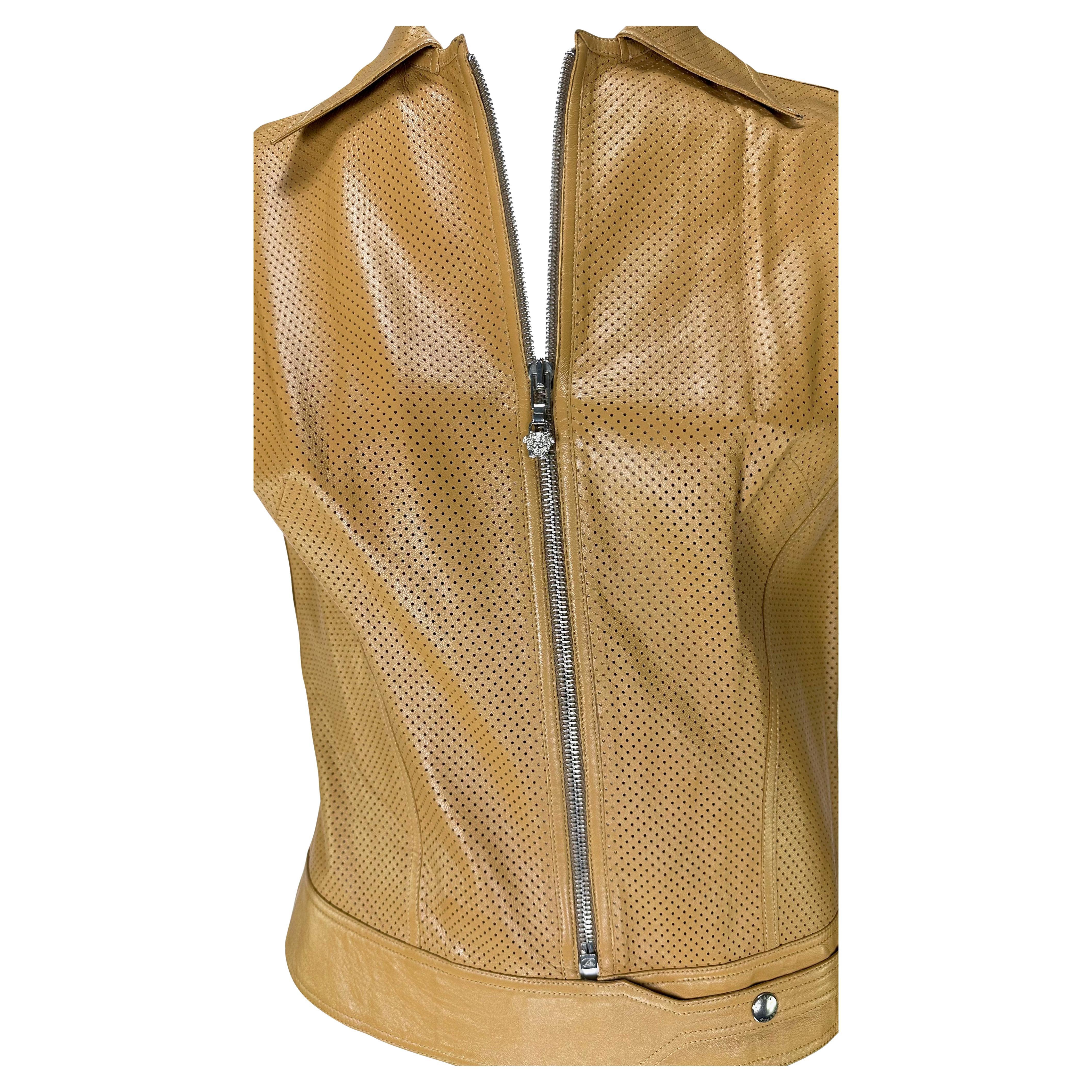 Presenting a tan Versace perforated leather vest, designed by Donatella Versace. From the early 2000s, this fabulous vest is constructed of perforated leather and features a collar, belted snap waist, and is made complete with a silver-tone Versace