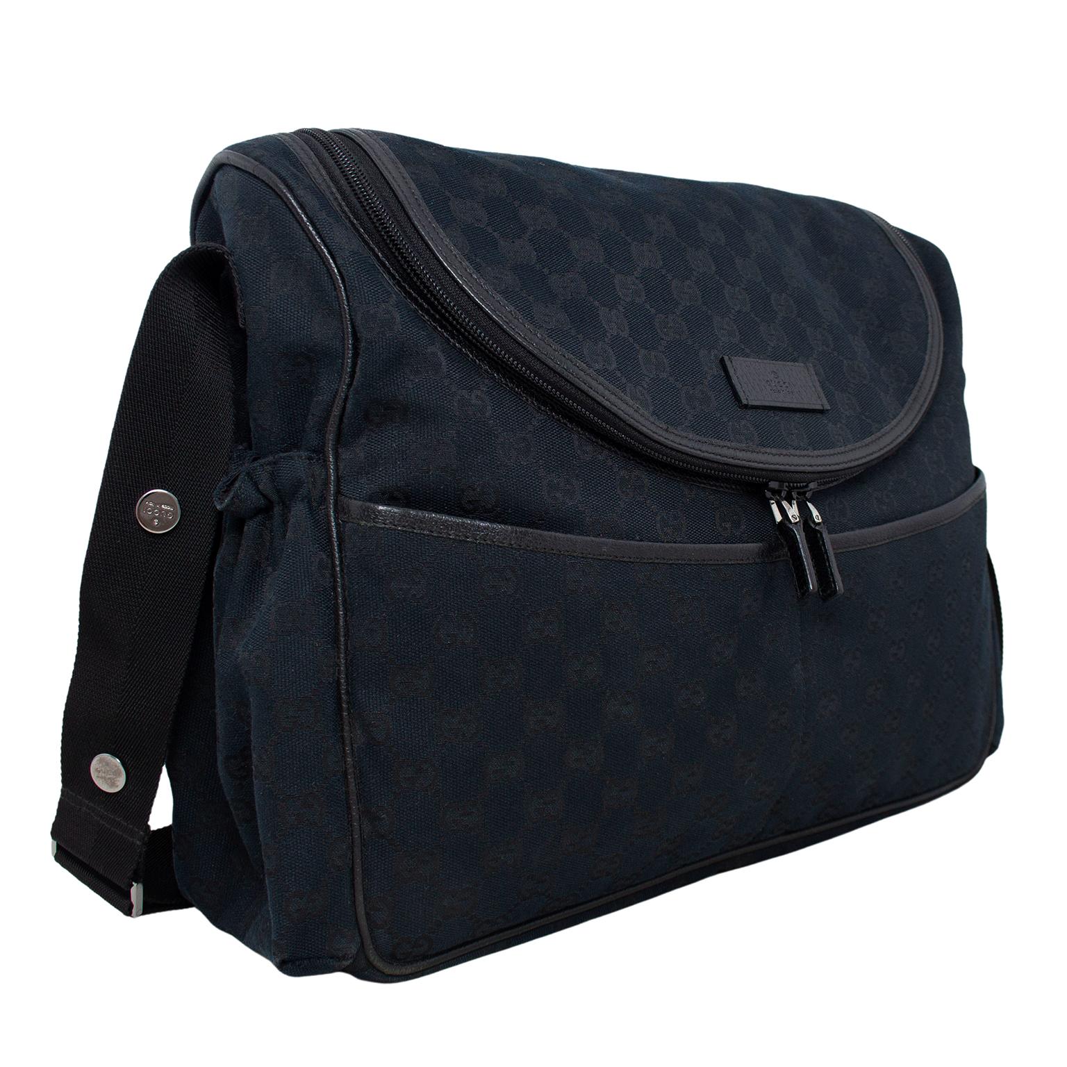 This Gucci diaper bag is the perfect mix of functional and chic. Black coated canvas with all over monochromatic Gucci logos and black leather trim. Exterior pockets on the front, back and sides for easy access to things that you need quickly.
