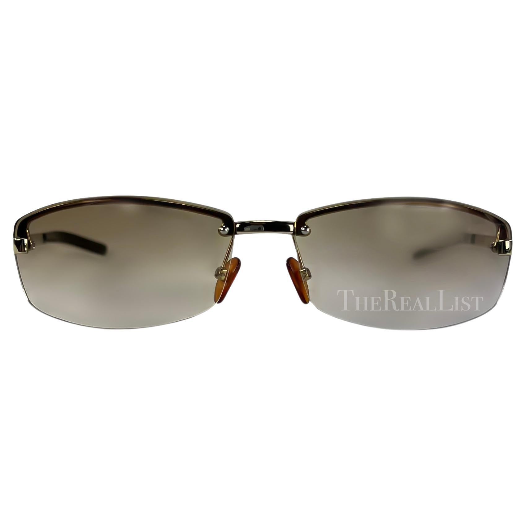 Présentation d'une paire de lunettes de soleil Gucci sans monture, de couleur marron, conçues par Tom Ford. Datant du début des années 2000, ces lunettes de soleil sont dotées d'un verre légèrement teinté et de fines branches argentées, rehaussées