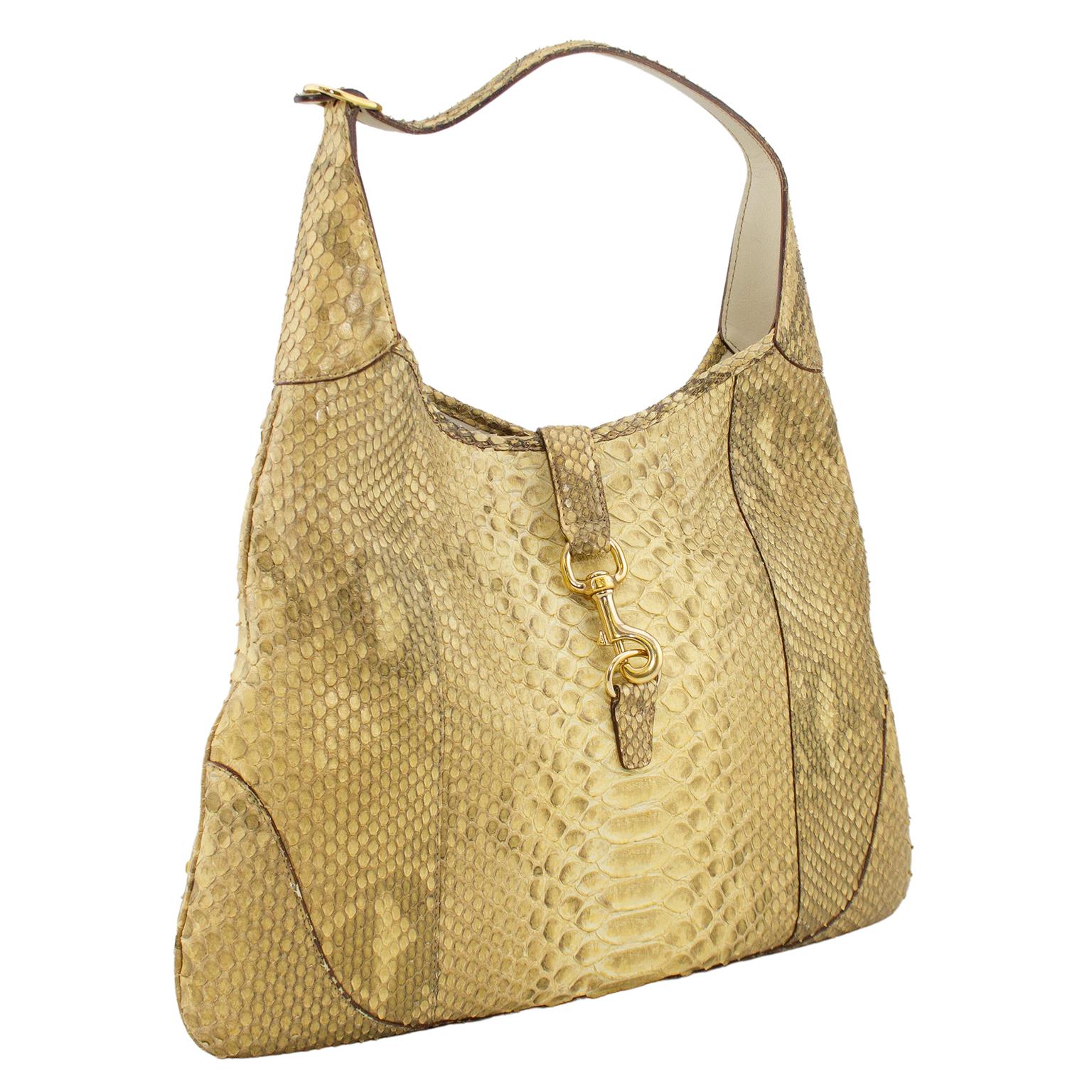 Metallic gold stamped leather Gucci large Jackie O Bouvier Bag with gold-tone hardware, flat shoulder strap, tan and cream canvas lining, dual pockets at interior walls; one with zip closure and one small and narrow for a lipstick. A classic and